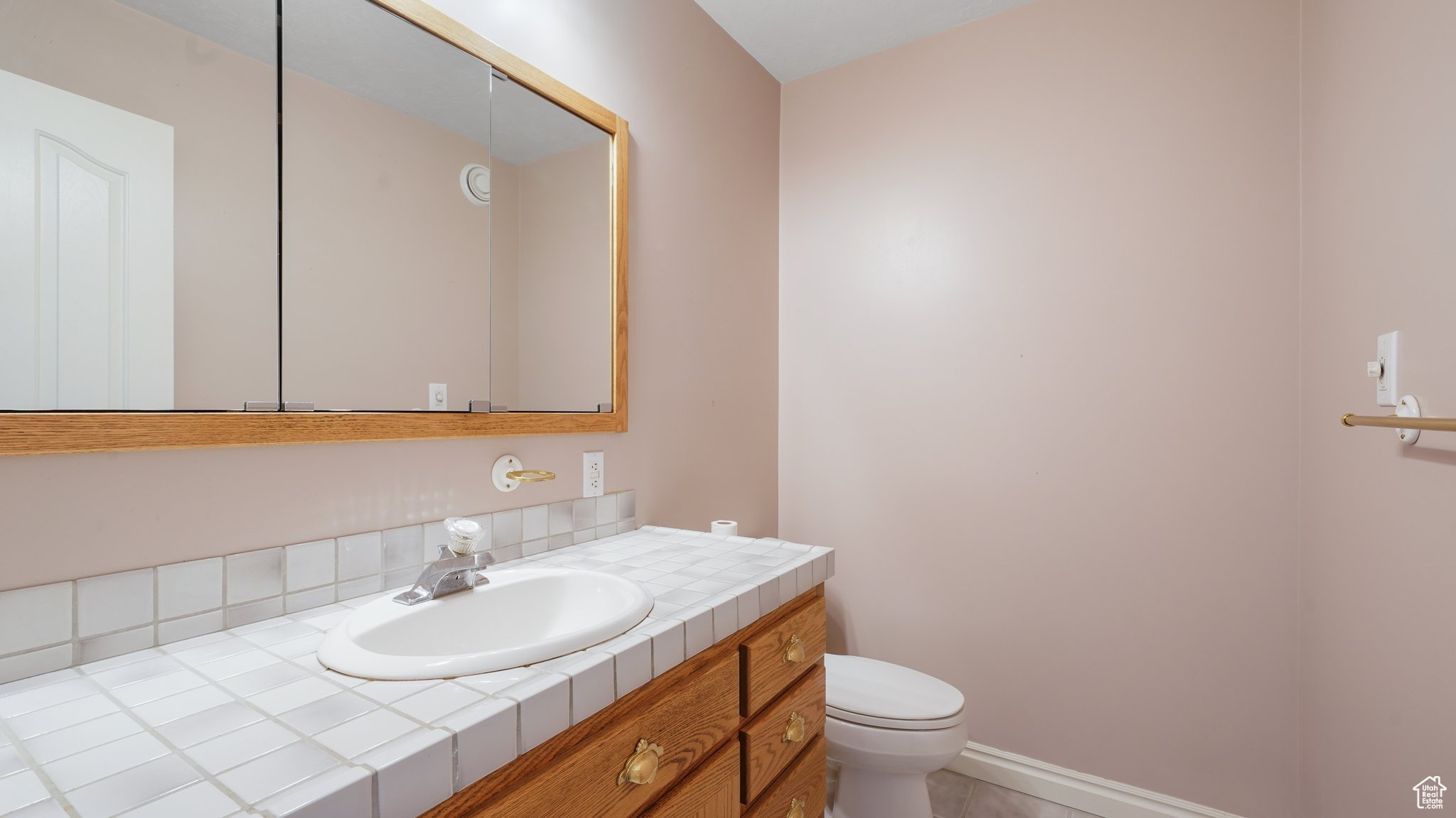 Bathroom featuring vanity, tile patterned flooring, and toilet