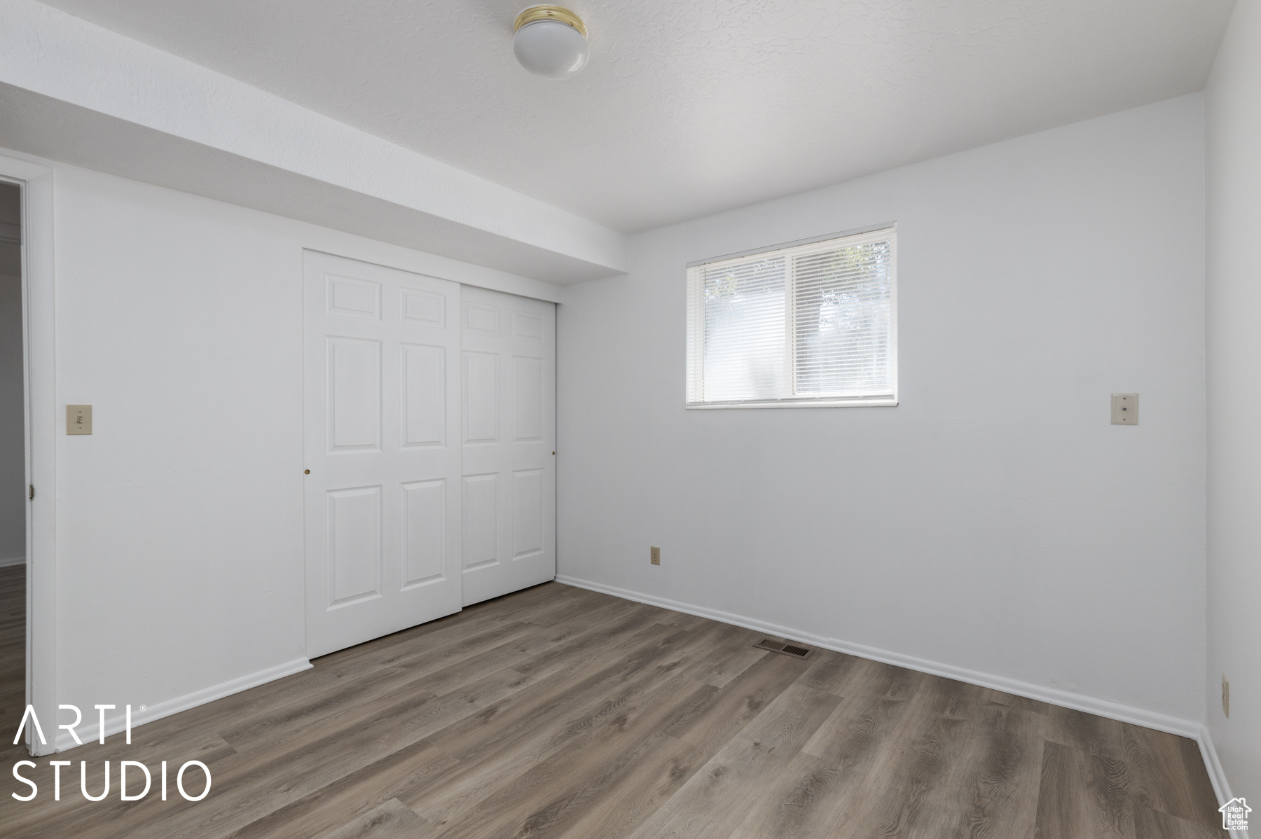 Unfurnished bedroom featuring hardwood / wood-style flooring and a closet