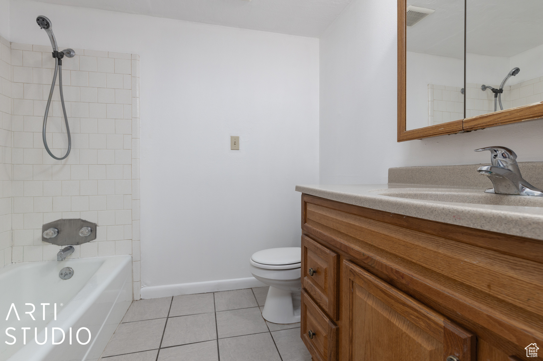 Full bathroom featuring tile patterned floors, toilet, vanity, and tiled shower / bath