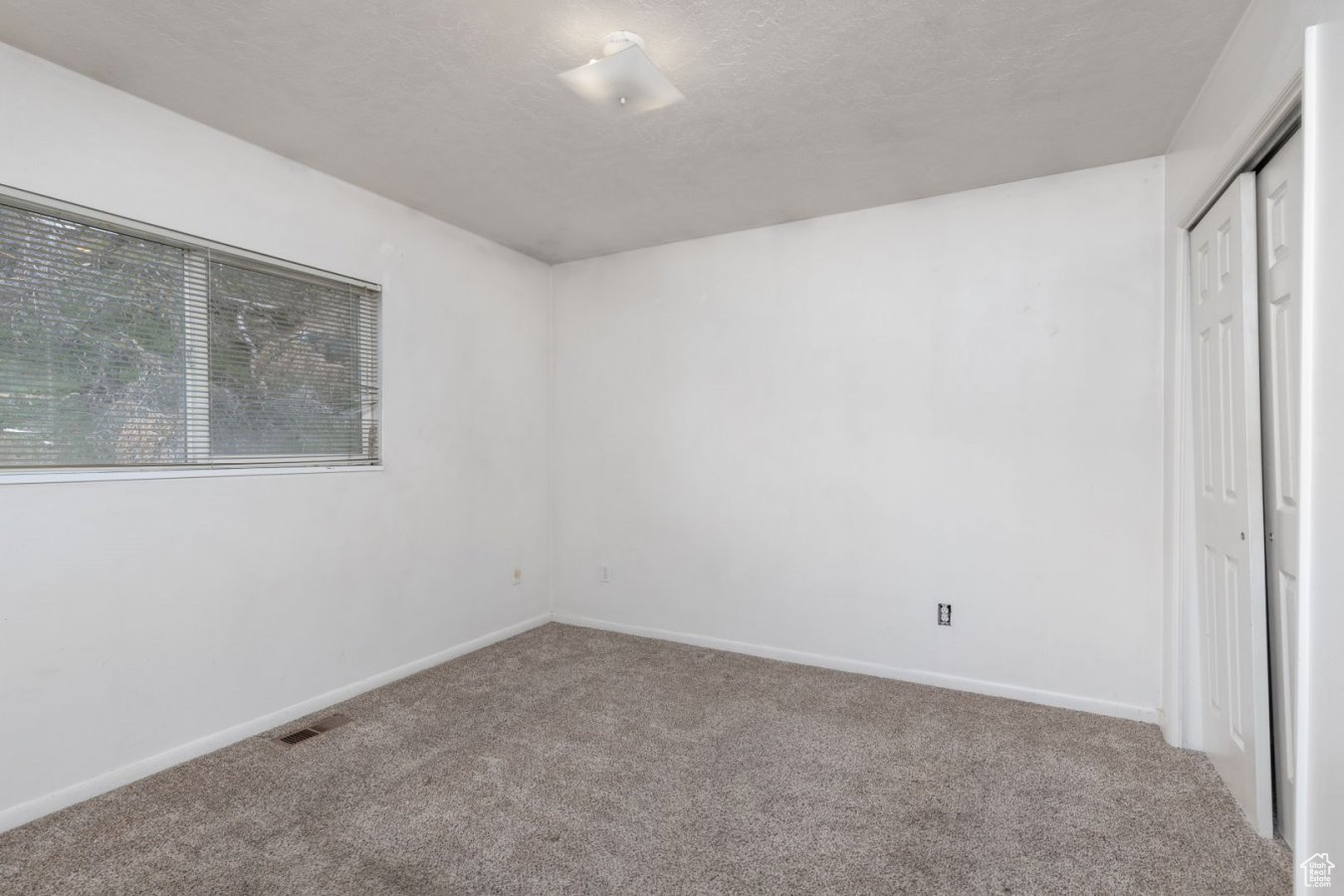 Unfurnished bedroom with a closet, carpet floors, and a textured ceiling