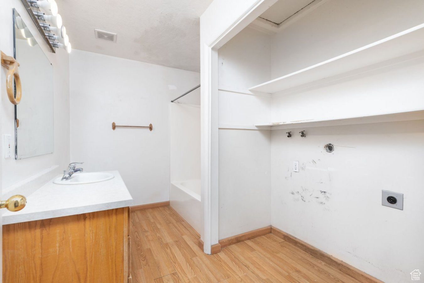 Interior space featuring hardwood / wood-style flooring, shower / bath combination, and vanity