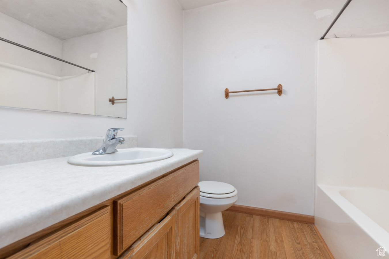 Full bathroom featuring washtub / shower combination, hardwood / wood-style flooring, toilet, and vanity