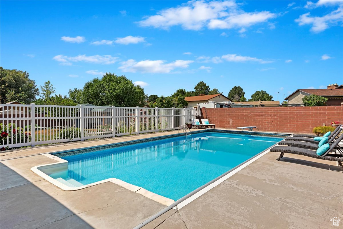 View of pool with a patio and a diving board