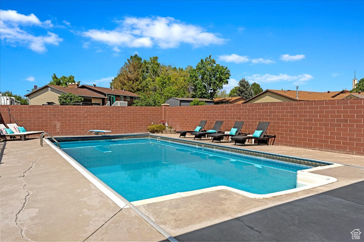 View of swimming pool featuring a diving board and a patio area