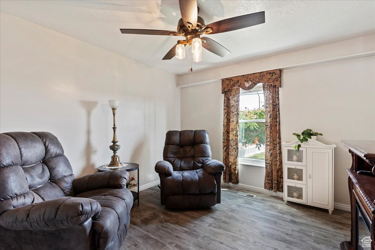 Living area with wood-type flooring and ceiling fan