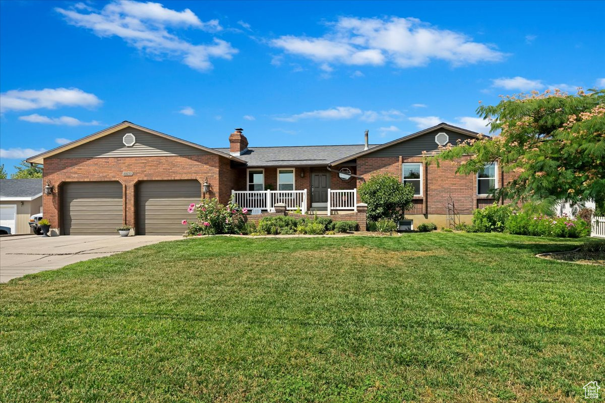 Single story home featuring a garage and a front yard