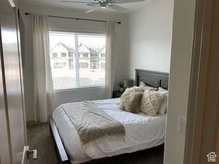 Carpeted bedroom featuring ceiling fan