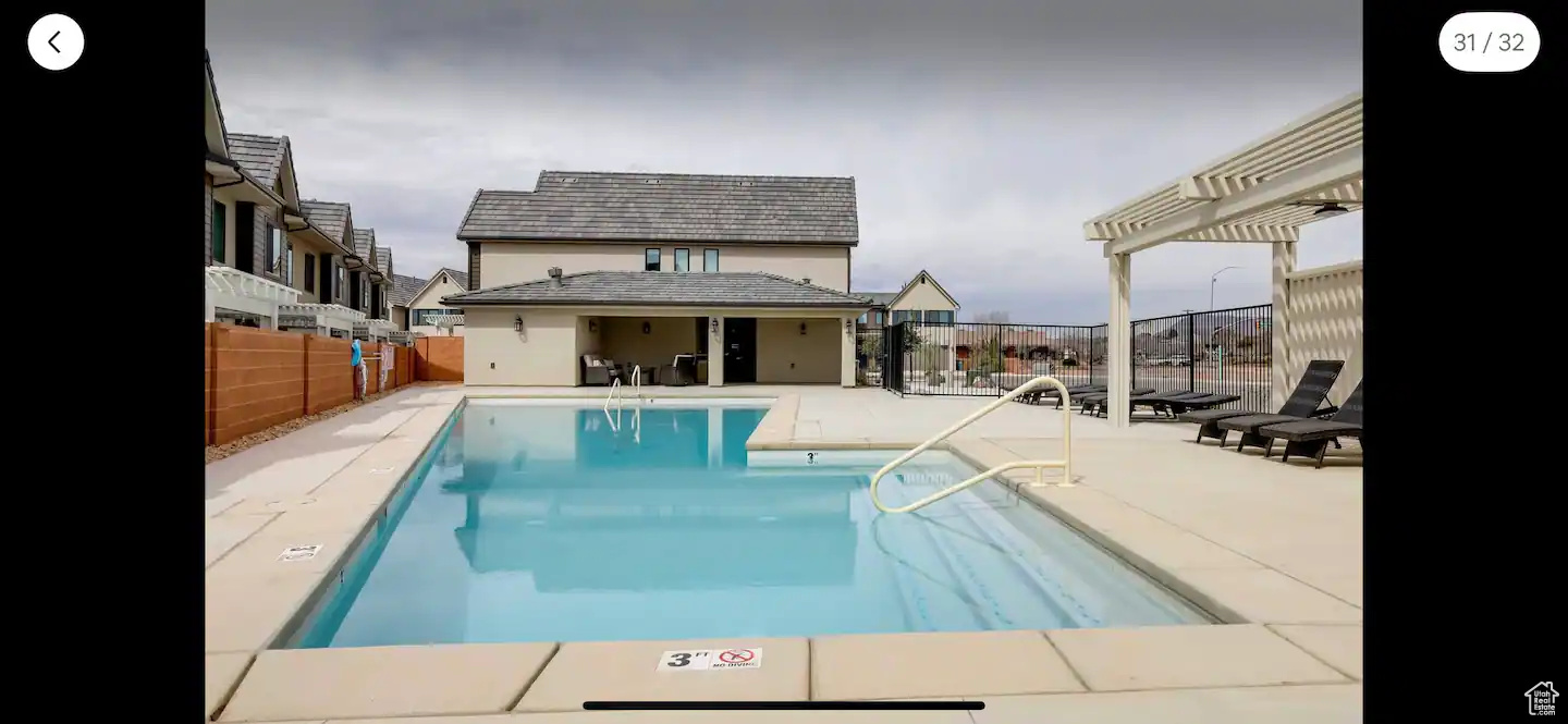 View of pool with a patio area and a pergola