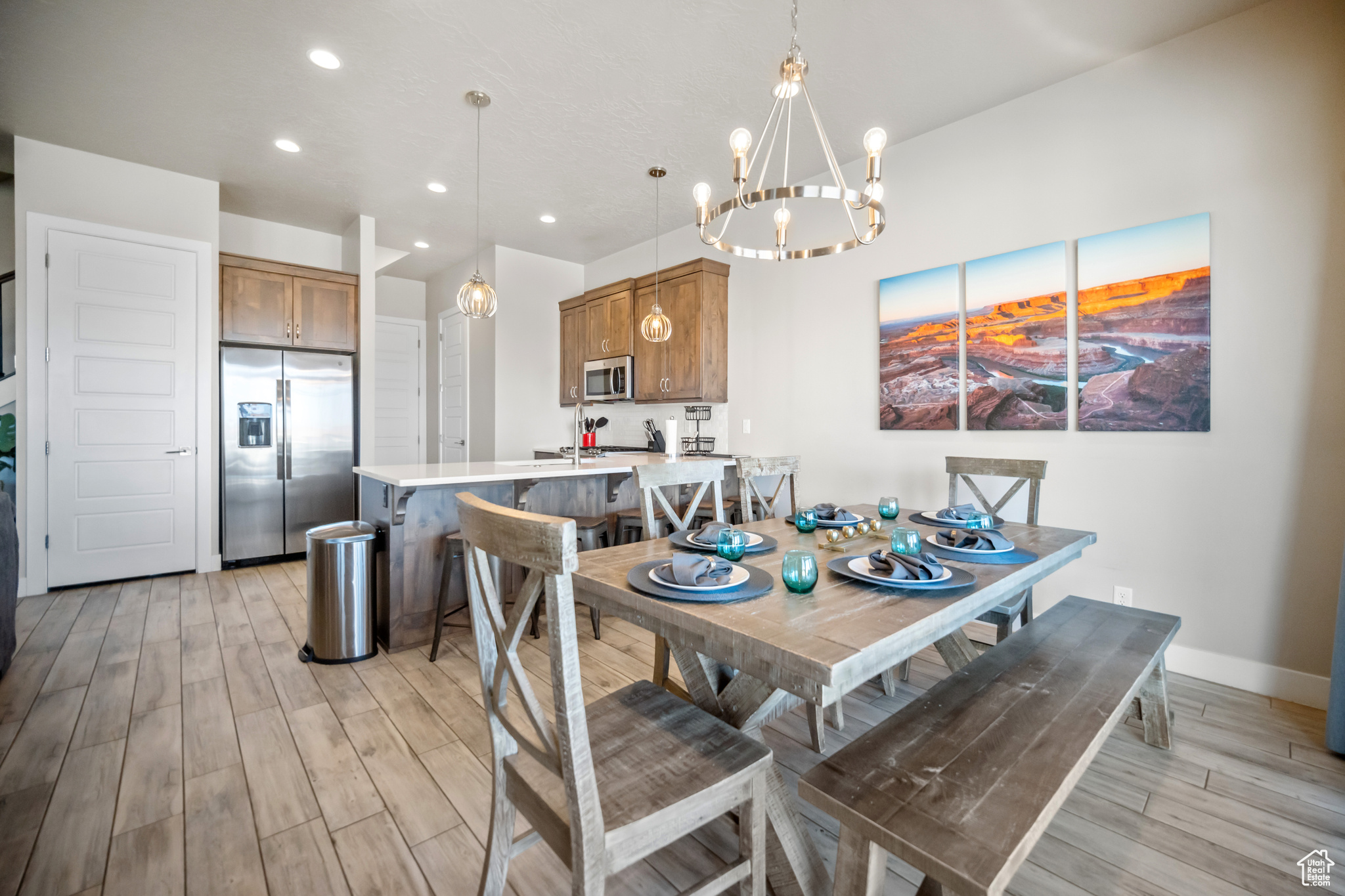 Dining room with light hardwood / wood-style floors and a notable chandelier