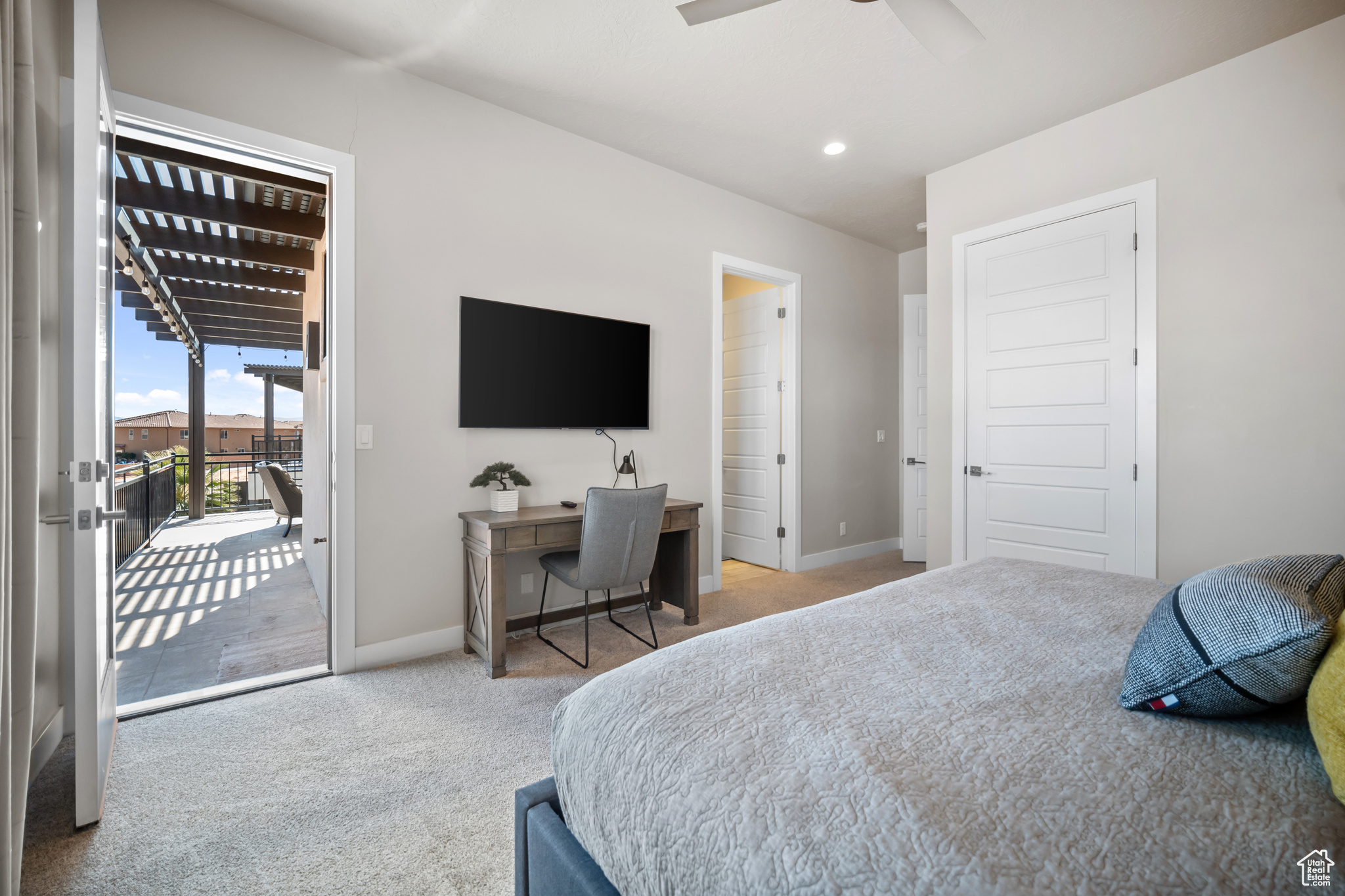 Bedroom featuring light carpet, ceiling fan, and access to exterior