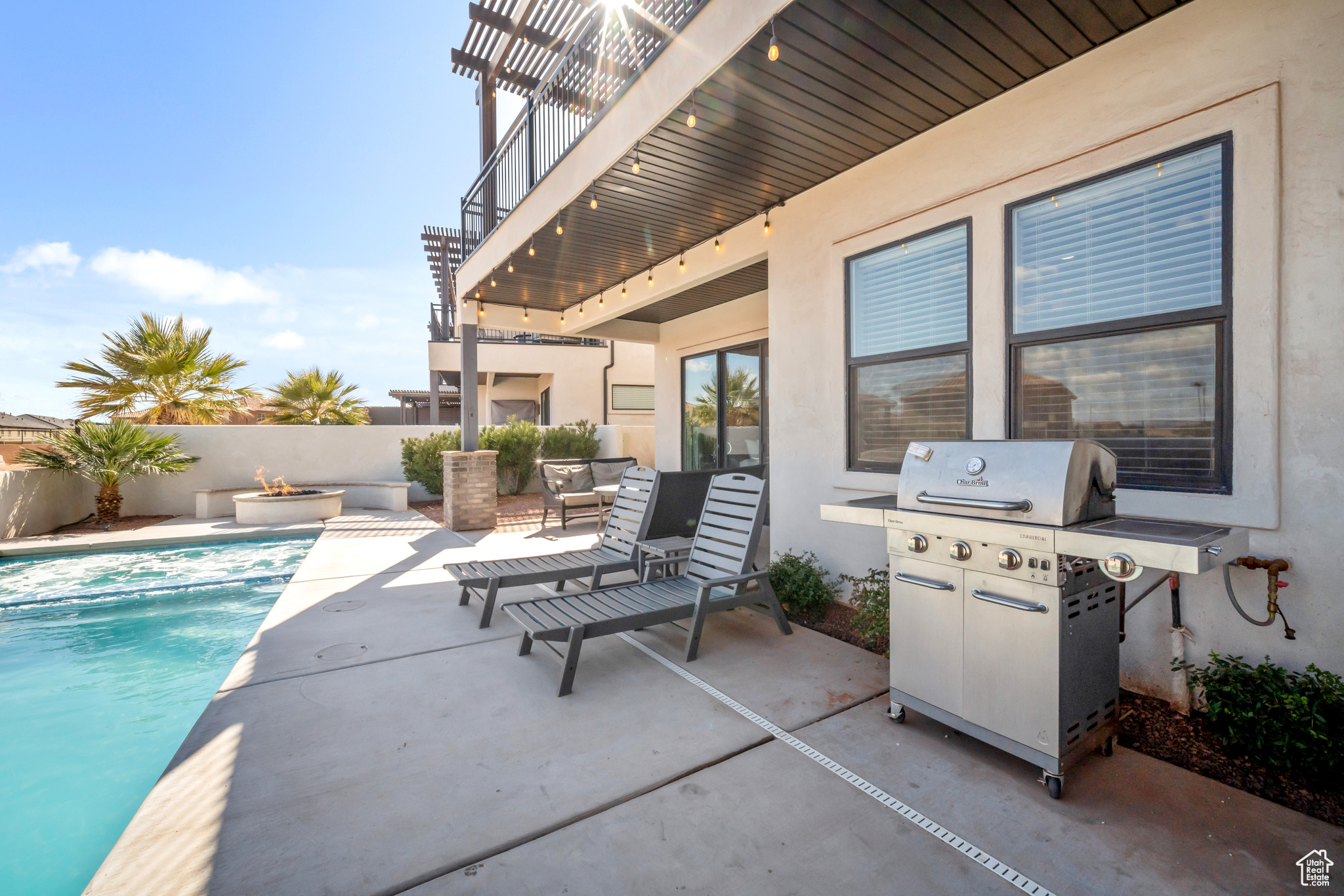 View of patio with a balcony, grilling area, and a fenced in pool