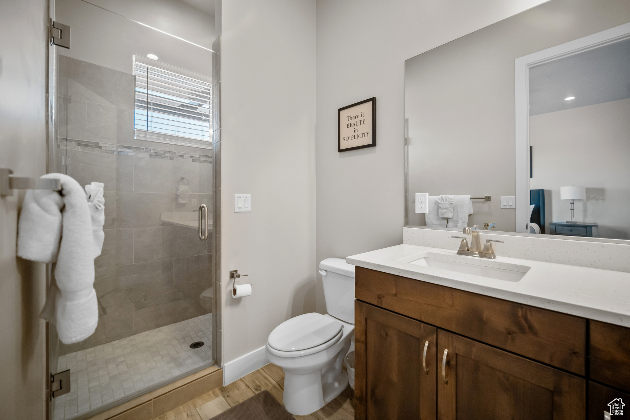 Bathroom featuring hardwood / wood-style floors, vanity, an enclosed shower, and toilet