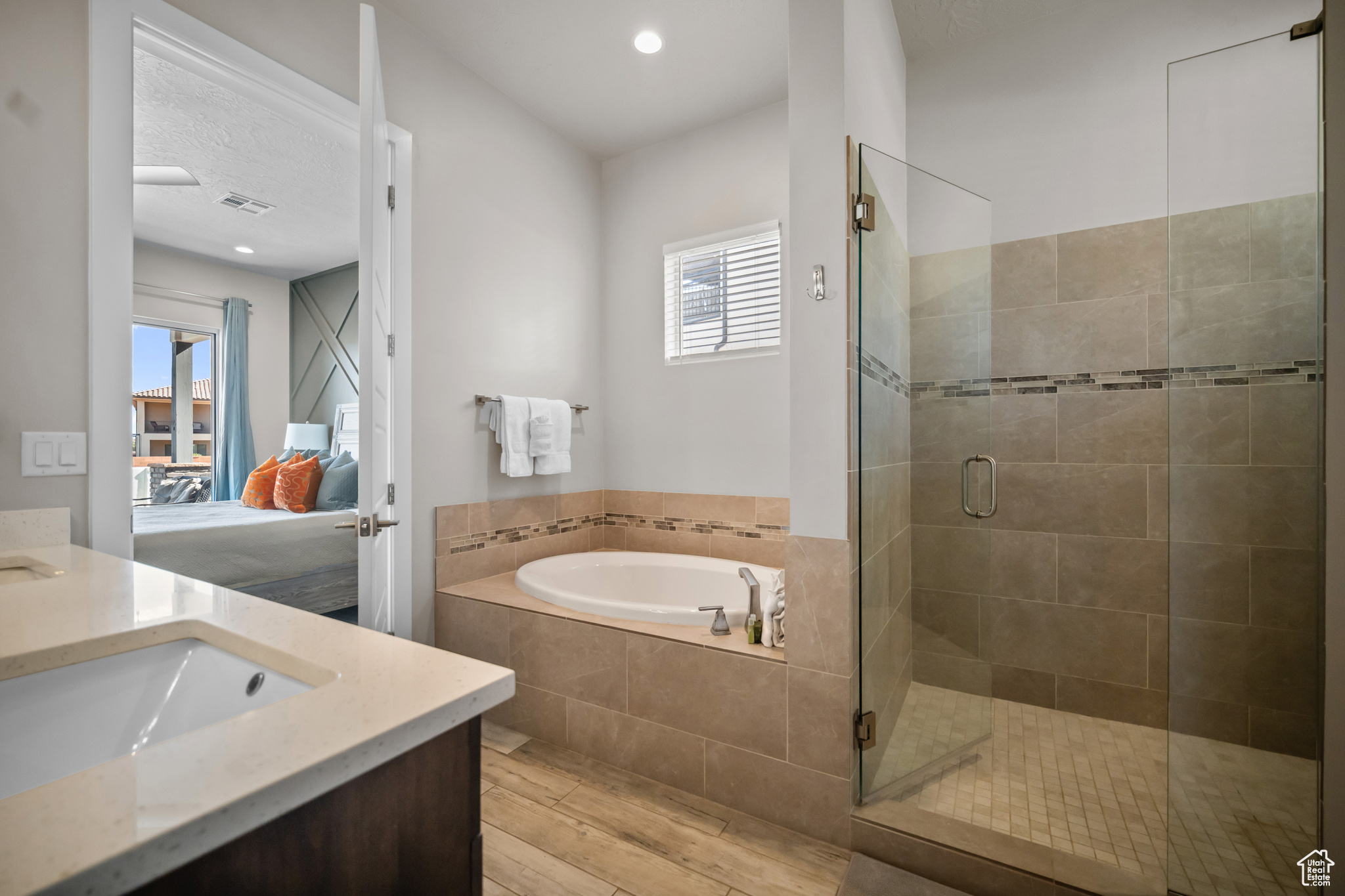 Bathroom featuring vanity, independent shower and bath, and hardwood / wood-style floors