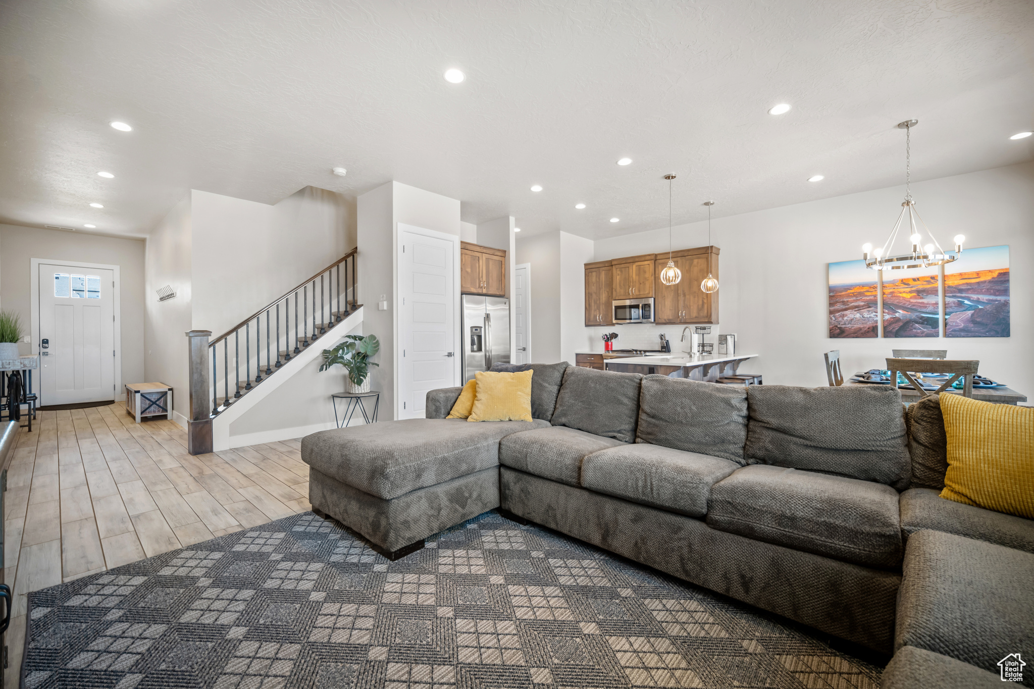 Living room with light hardwood / wood-style floors and an inviting chandelier