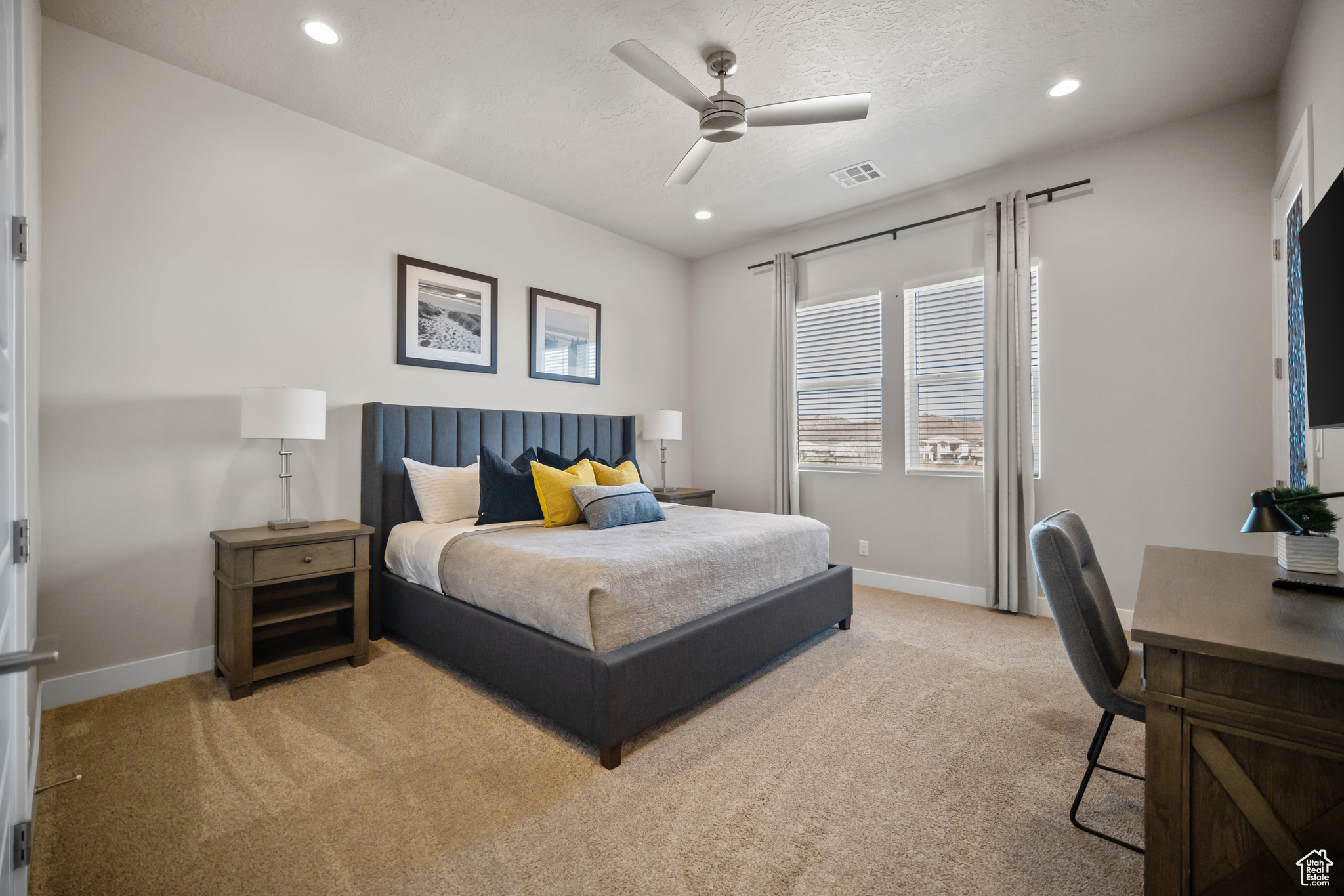 Carpeted bedroom featuring ceiling fan