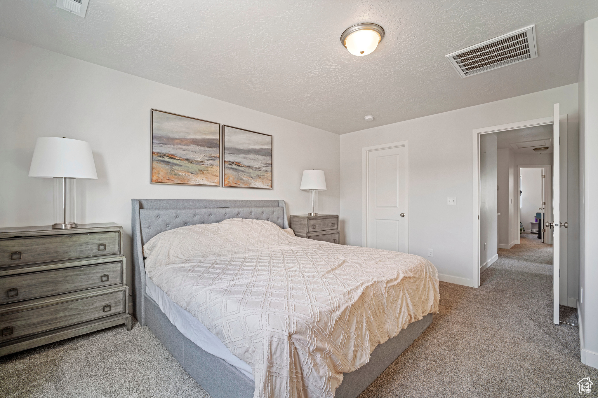 Bedroom featuring light carpet and a textured ceiling