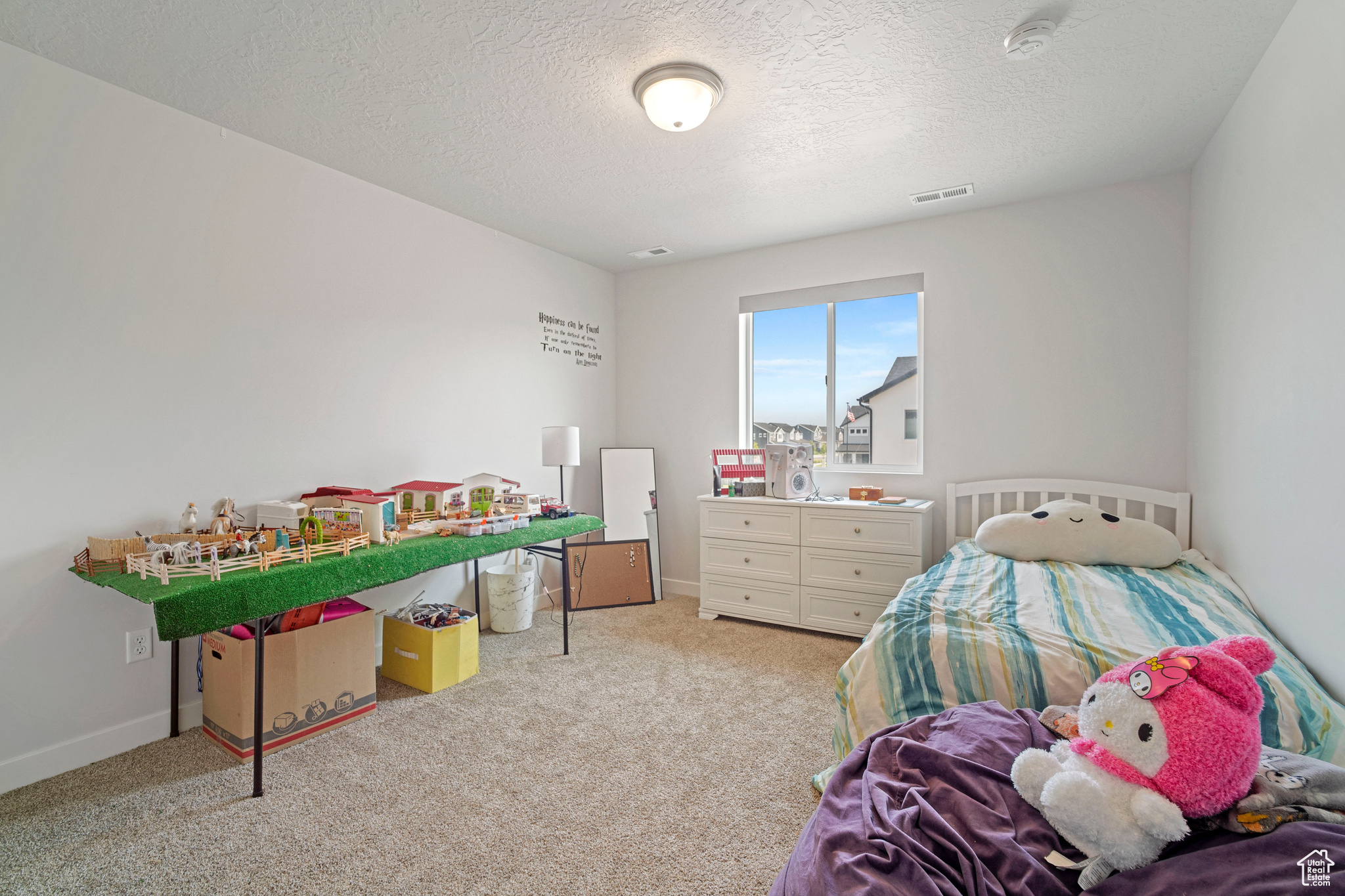 Bedroom featuring light colored carpet and a textured ceiling