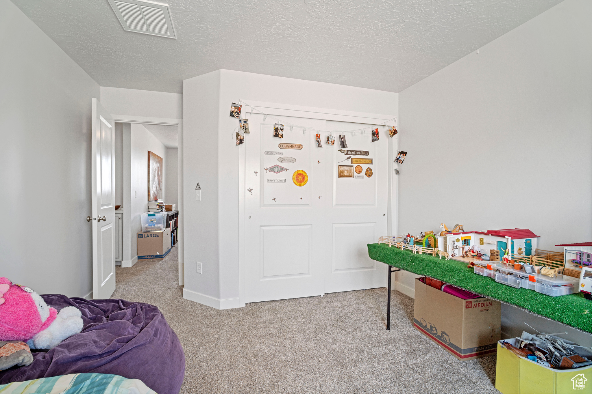 Bedroom with light carpet and a textured ceiling