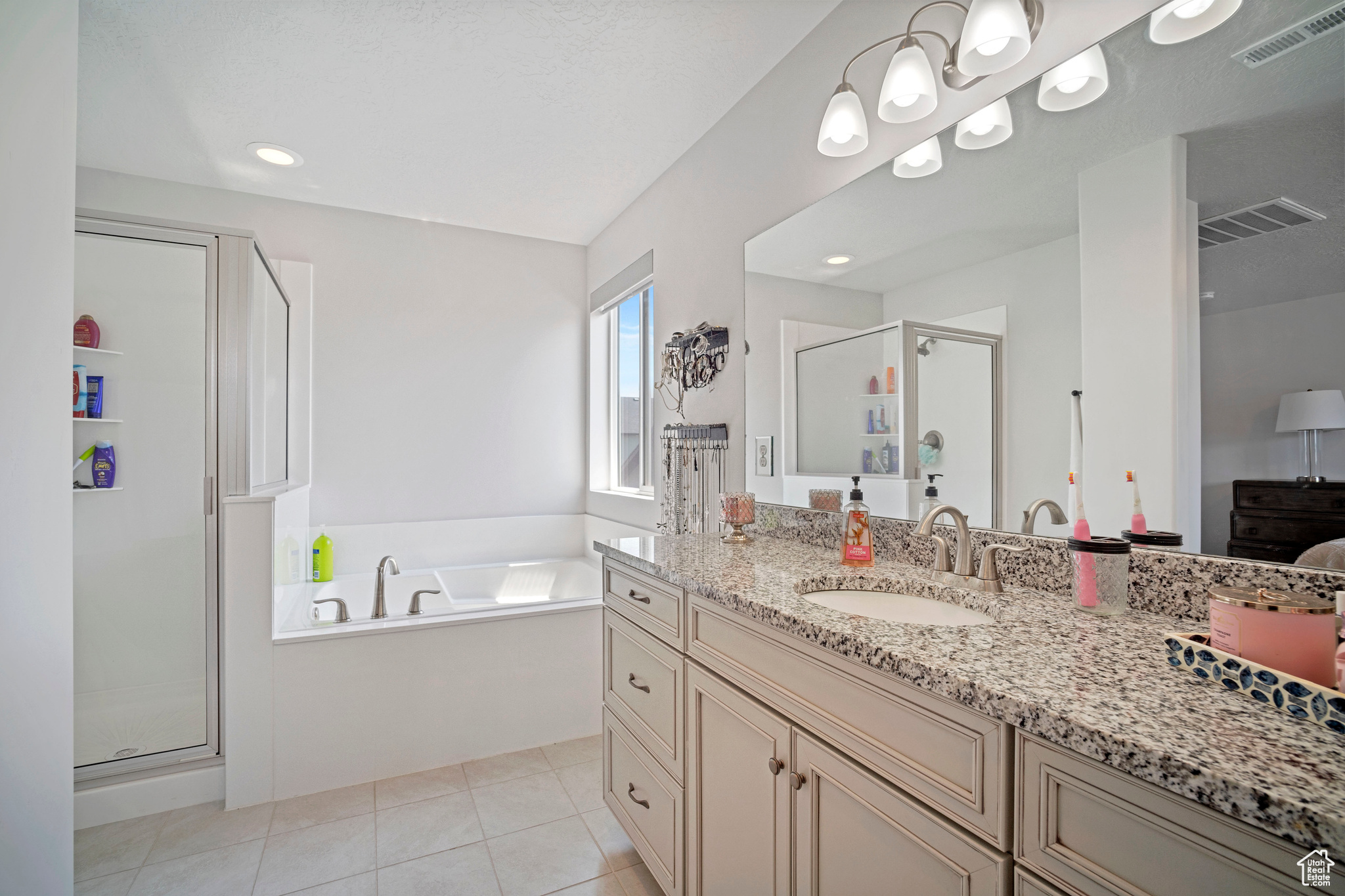 Bathroom with vanity, tile patterned floors, and shower with separate bathtub