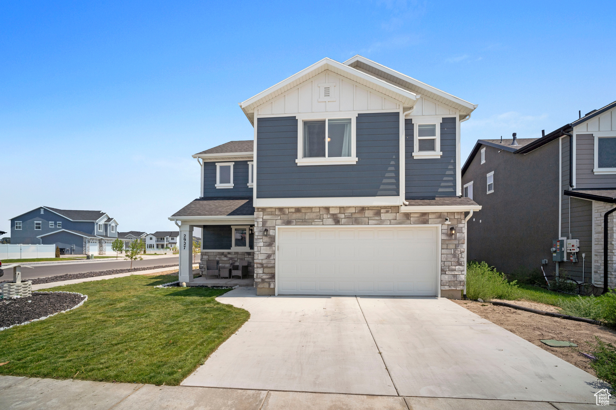 View of front of property featuring a garage and a front lawn