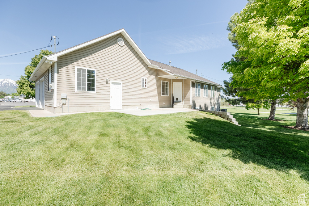 Back of property featuring a lawn