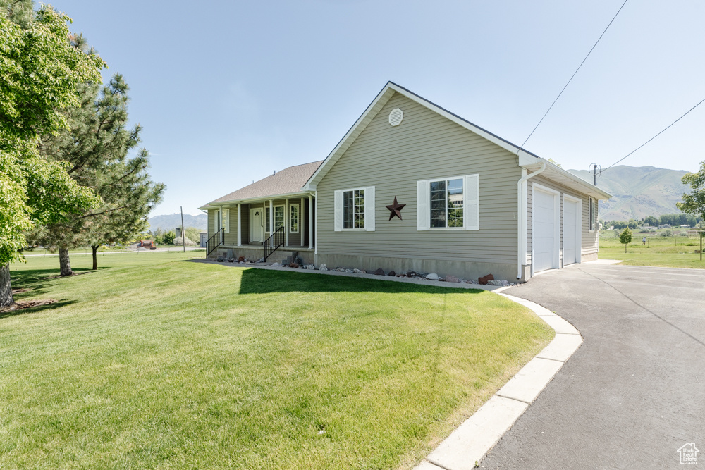 View of front of house featuring a garage, a mountain view, and a front yard