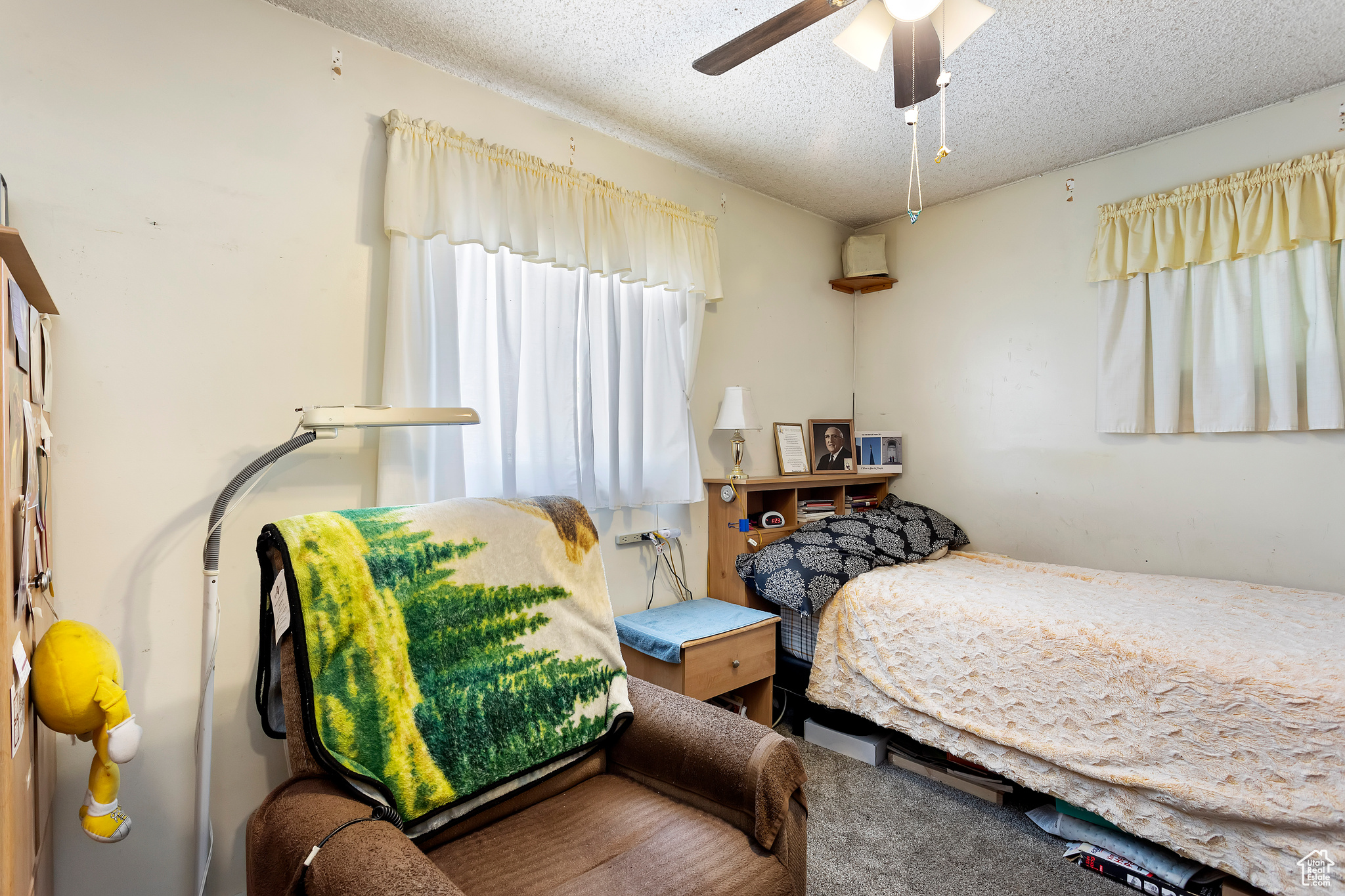 Bedroom with ceiling fan and a textured ceiling