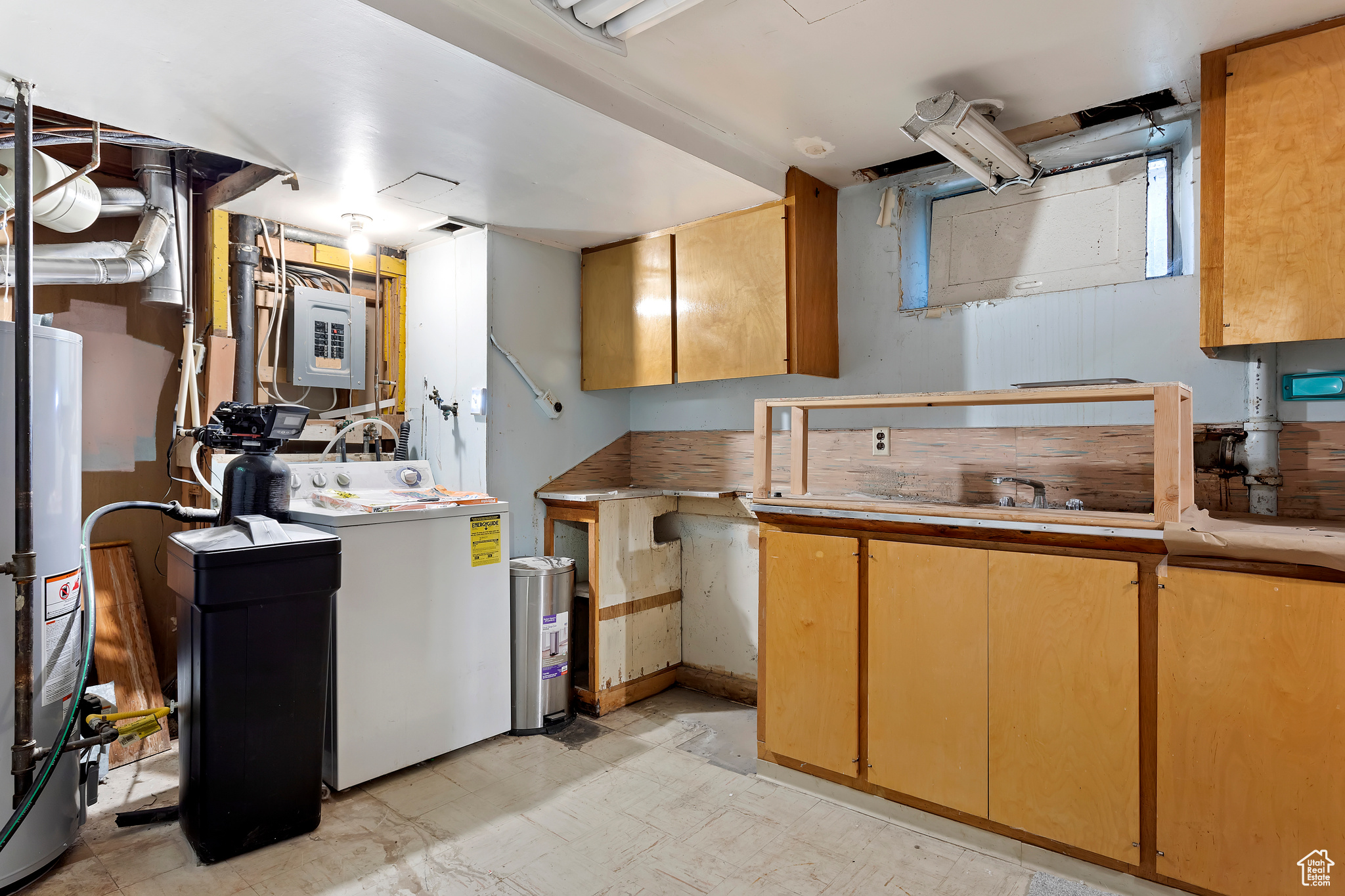 Kitchen with washer / clothes dryer, light tile patterned floors, and water heater