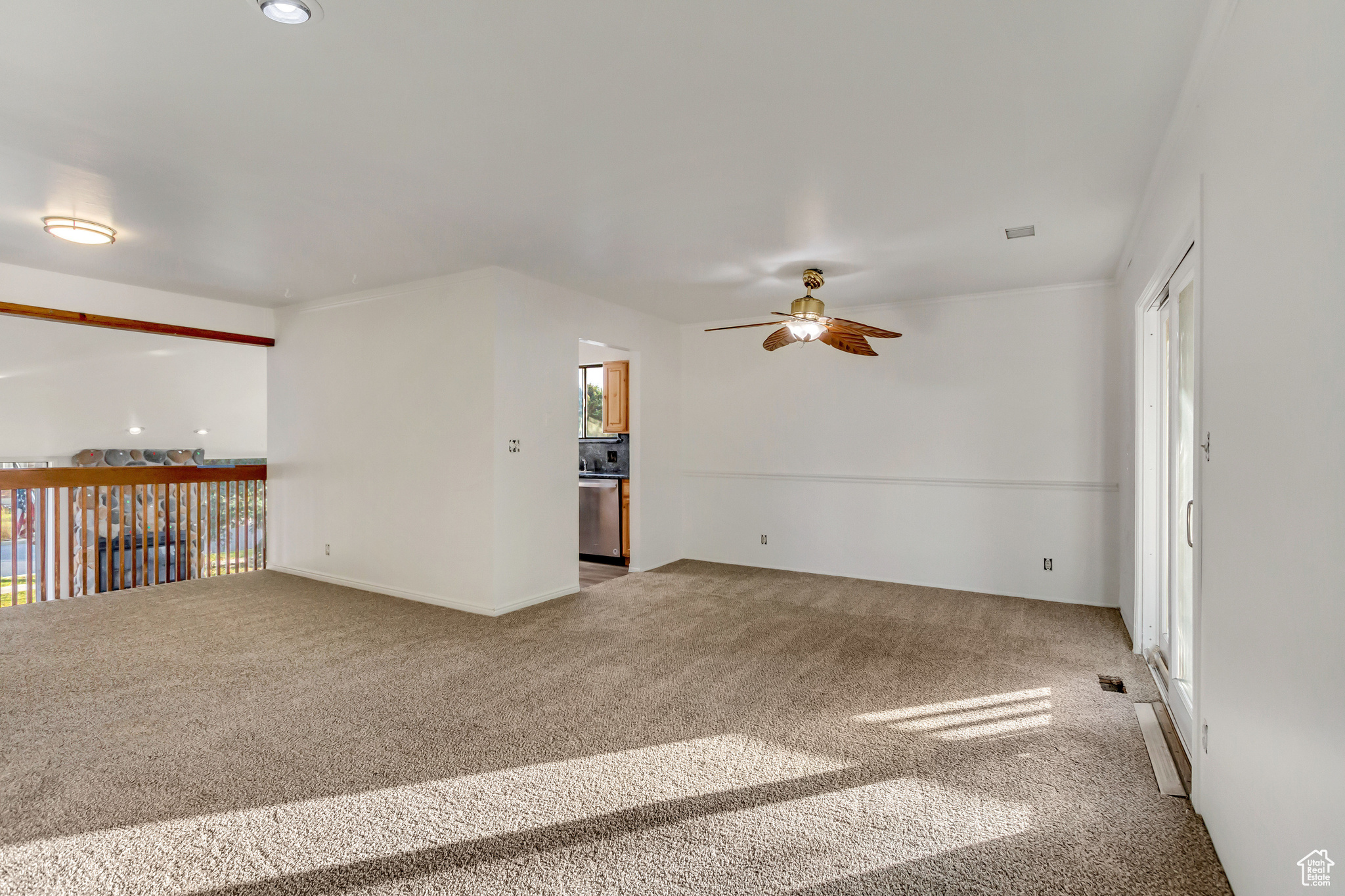 Carpeted empty room featuring ceiling fan