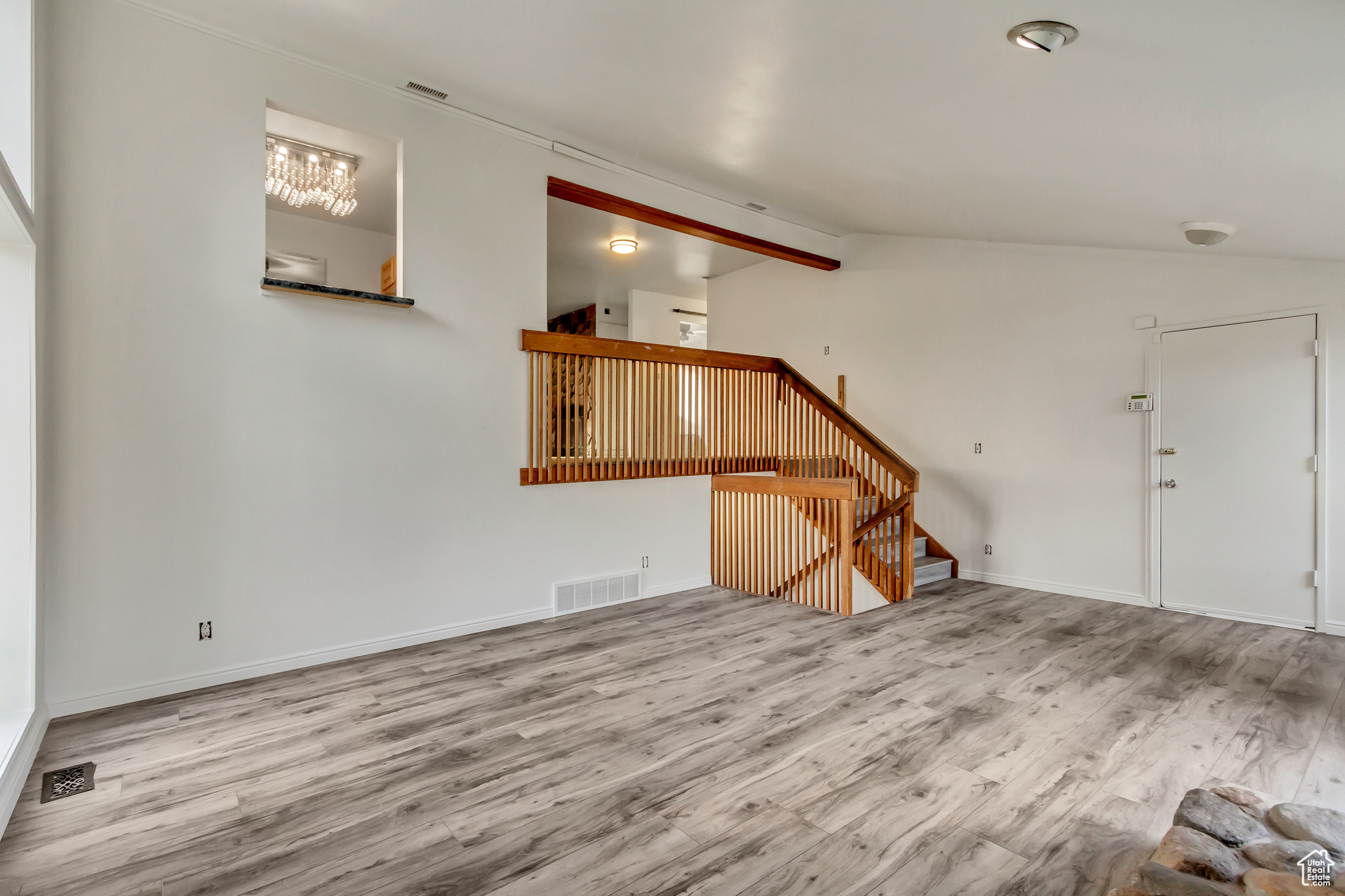 Unfurnished living room featuring lofted ceiling and hardwood / wood-style flooring