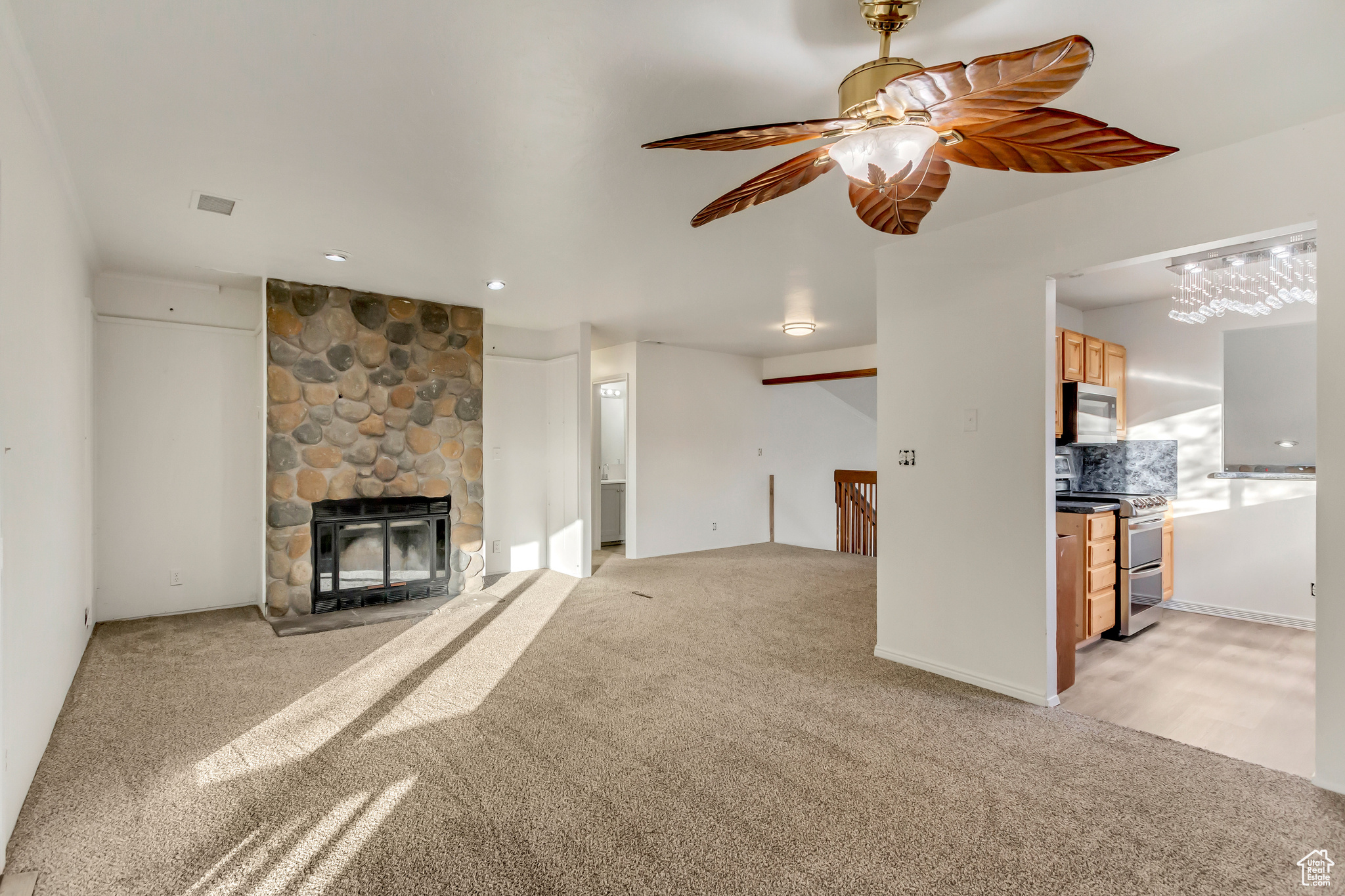 Unfurnished living room featuring light carpet and a fireplace