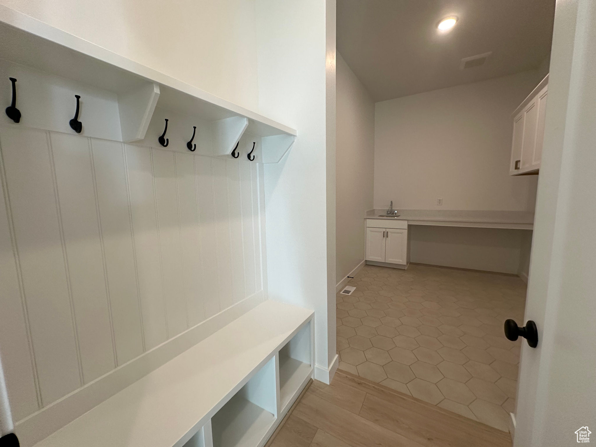 Mudroom with light hardwood / wood-style floors and sink