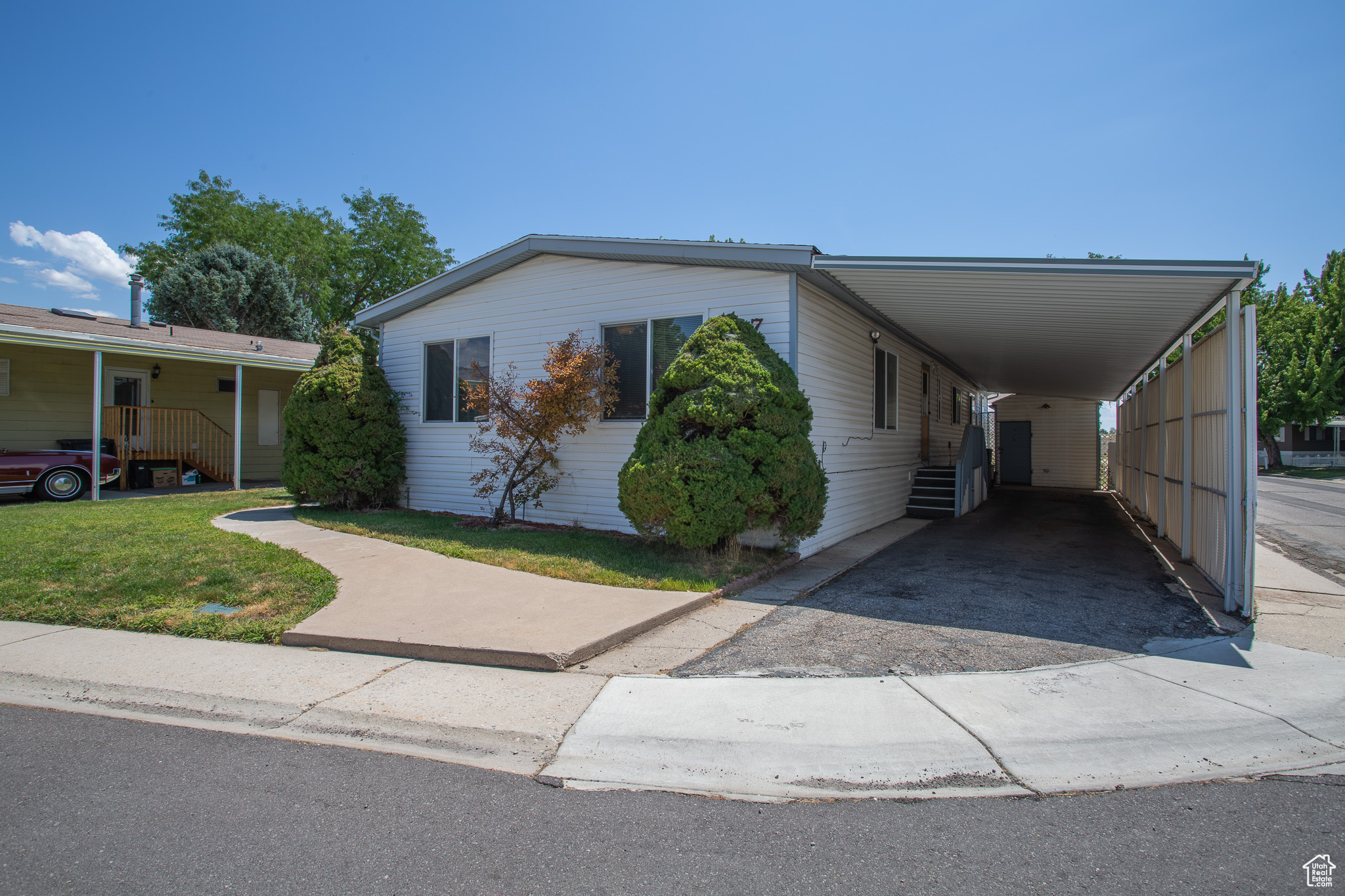 View of front facade with a carport and a front yard