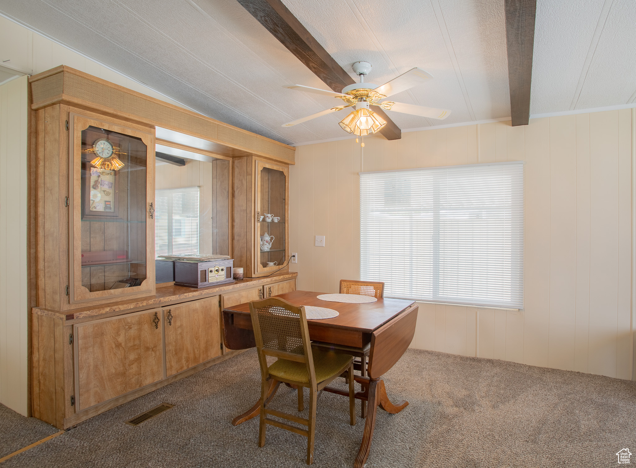 Carpeted dining area with built-in shelving