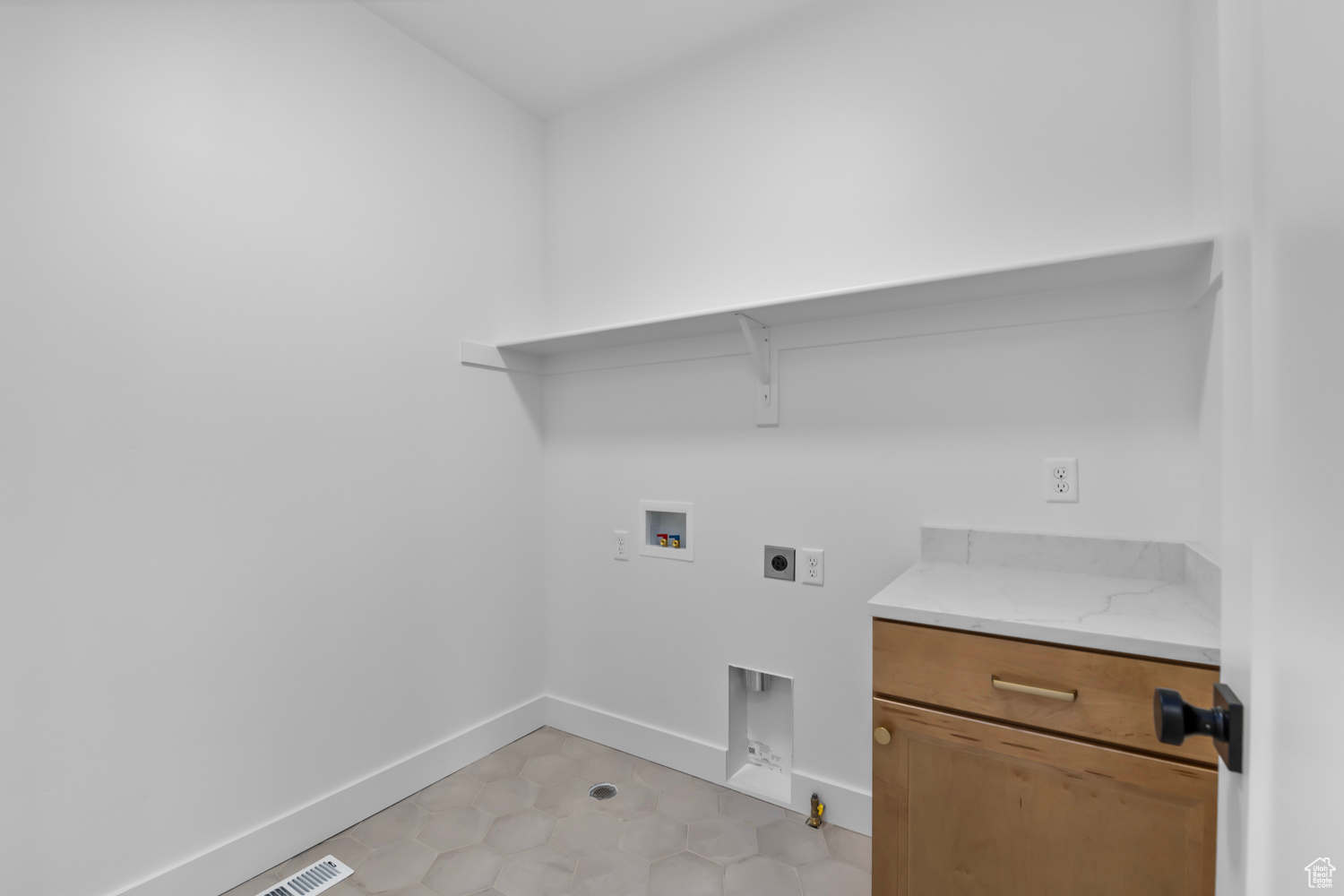 Clothes washing area with washer hookup, light tile patterned floors, electric dryer hookup, and hookup for a gas dryer