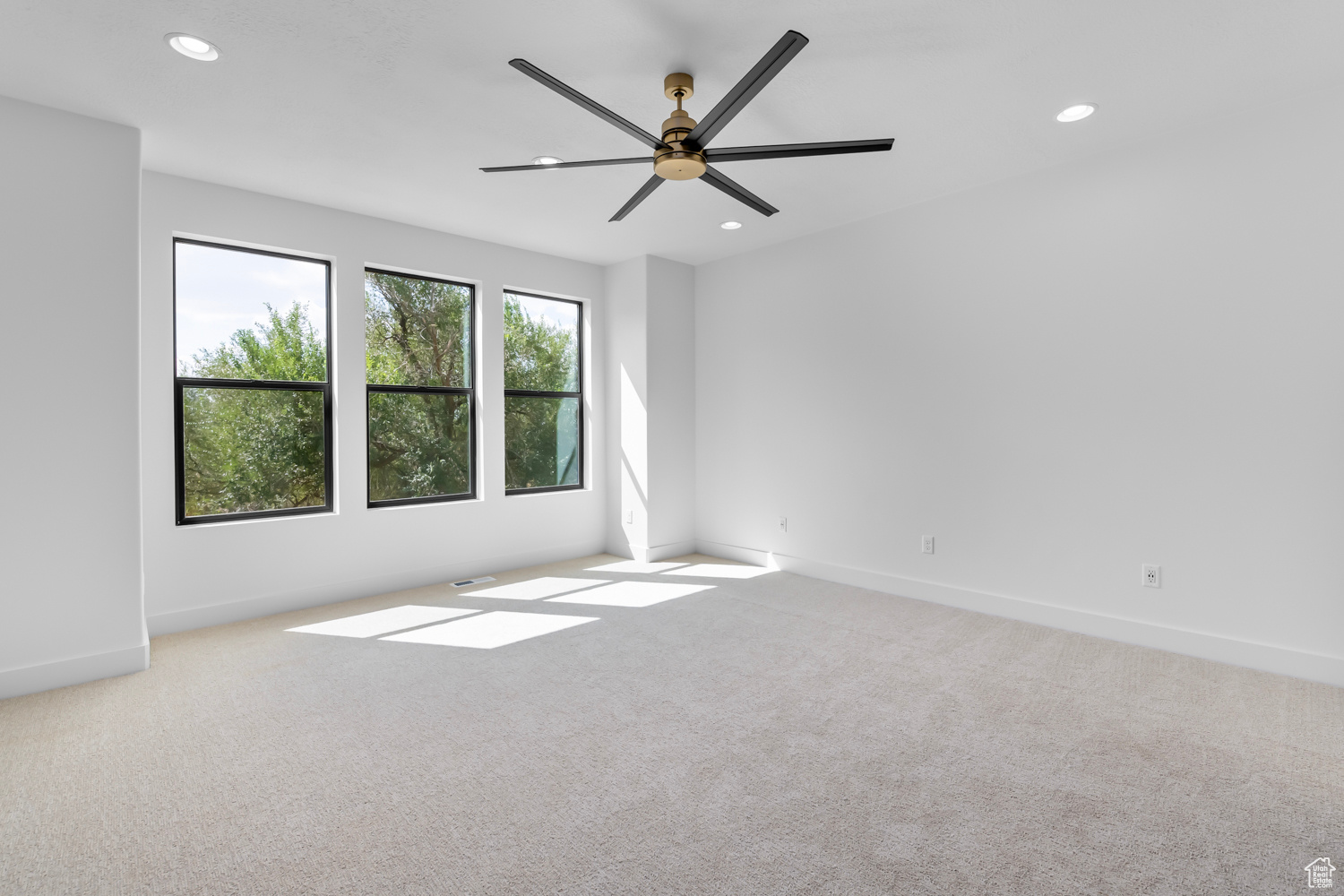 Carpeted spare room with ceiling fan