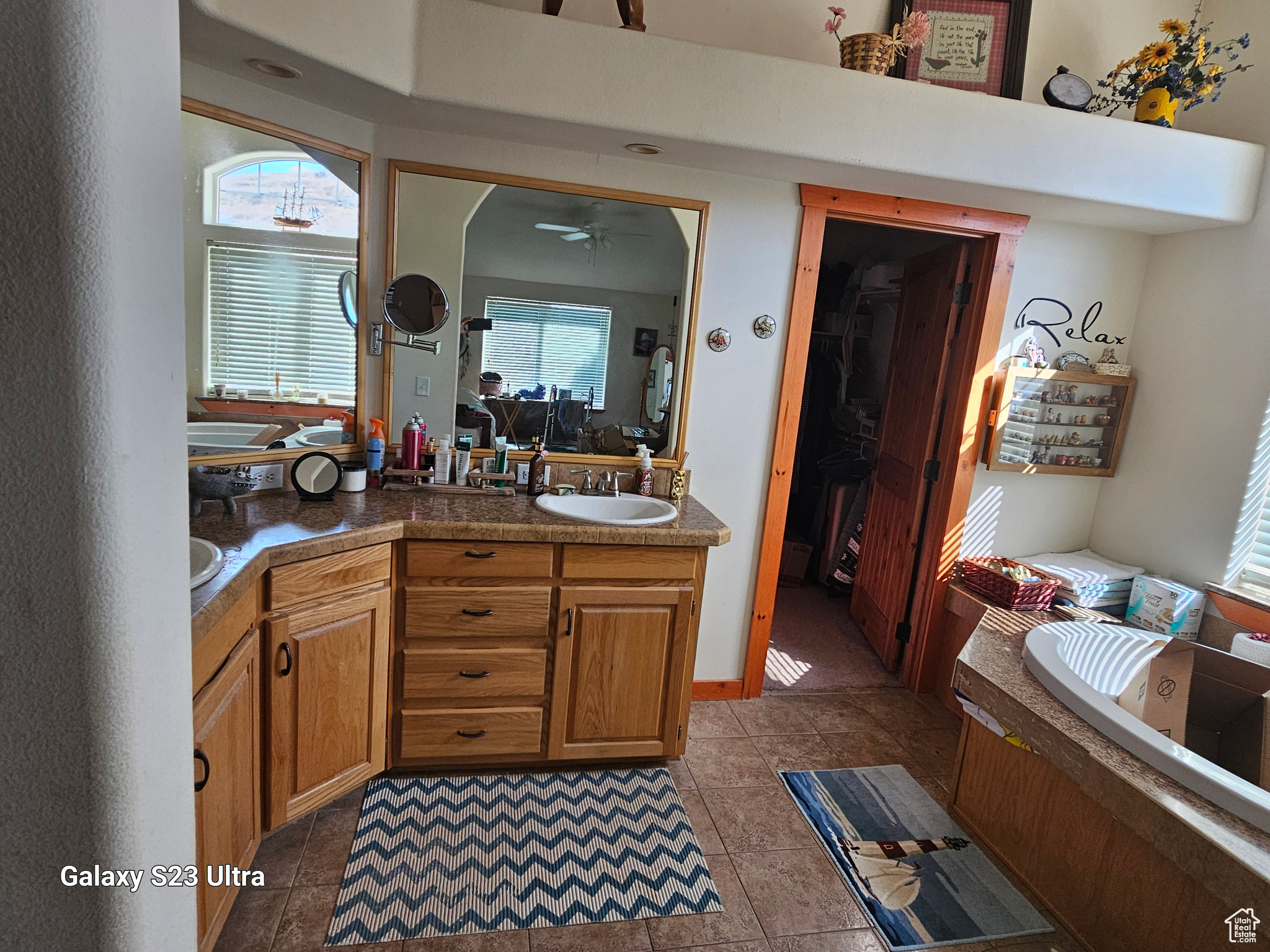 Bathroom with vanity, ceiling fan, a tub to relax in, and tile patterned floors, walk in closet.