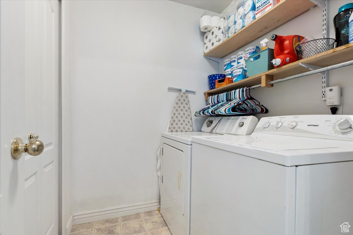 Washroom featuring separate washer and dryer and light tile patterned floors