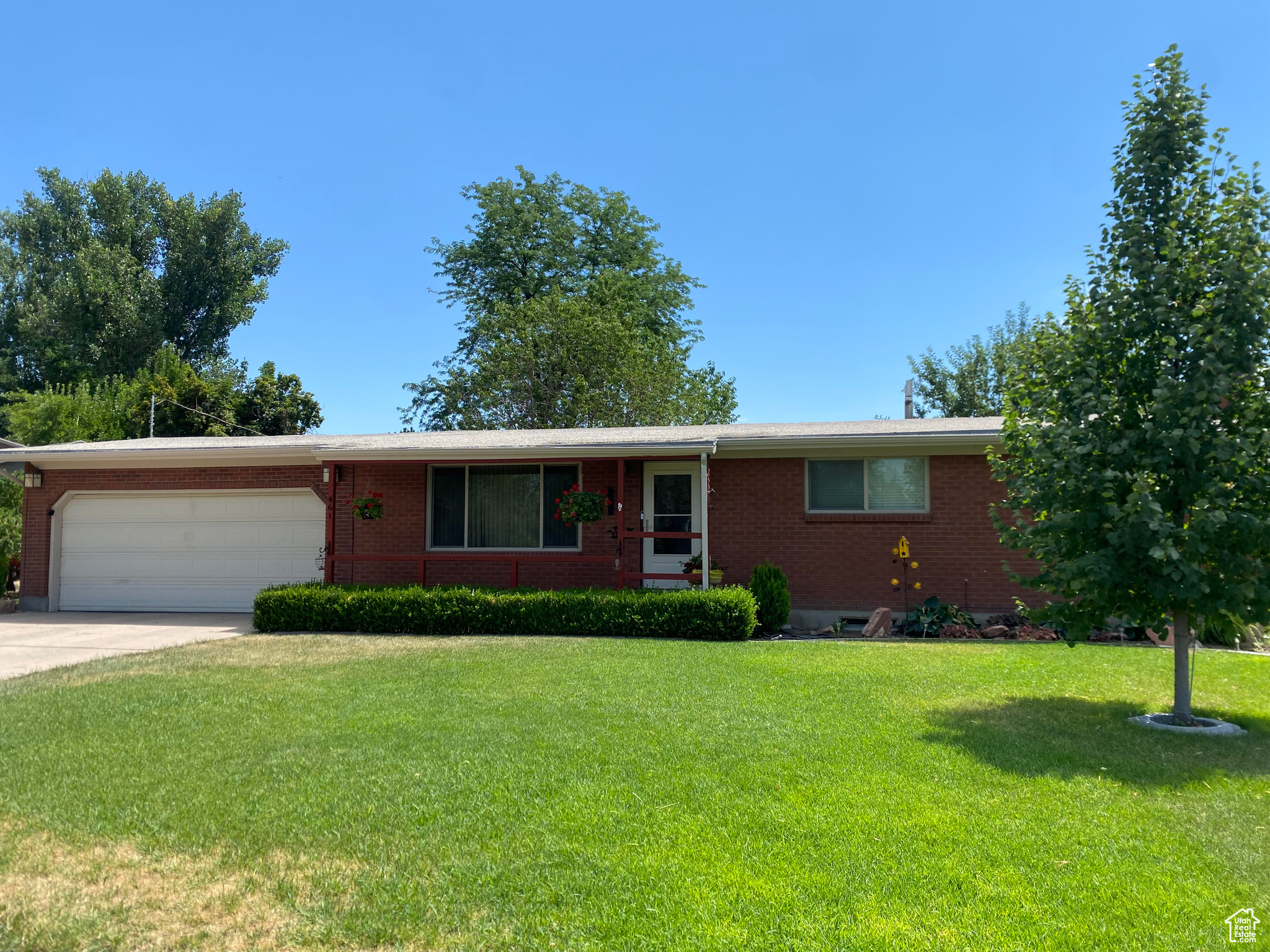 Ranch-style home with a garage and a front lawn