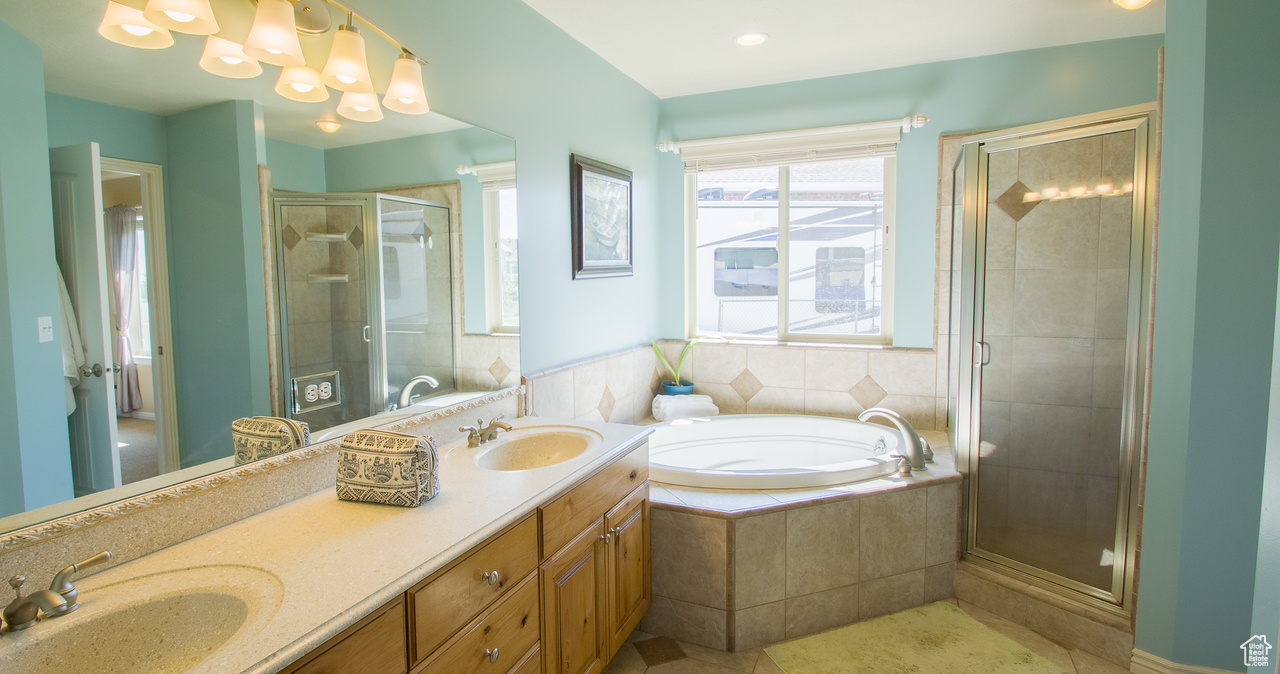 Primary Bathroom with separate shower and tub, tile patterned flooring, and double vanity