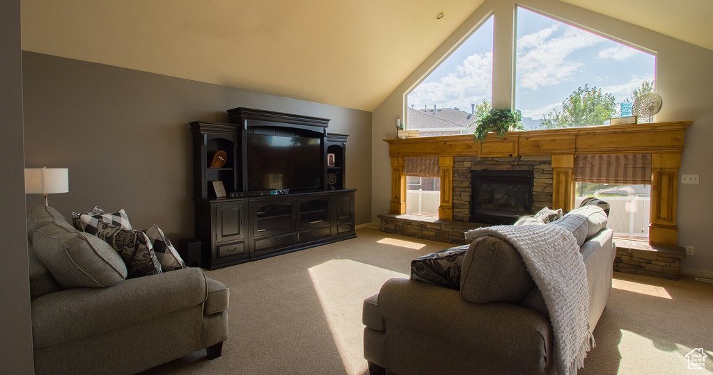 Living room with a stone fireplace, carpet, and high vaulted ceiling