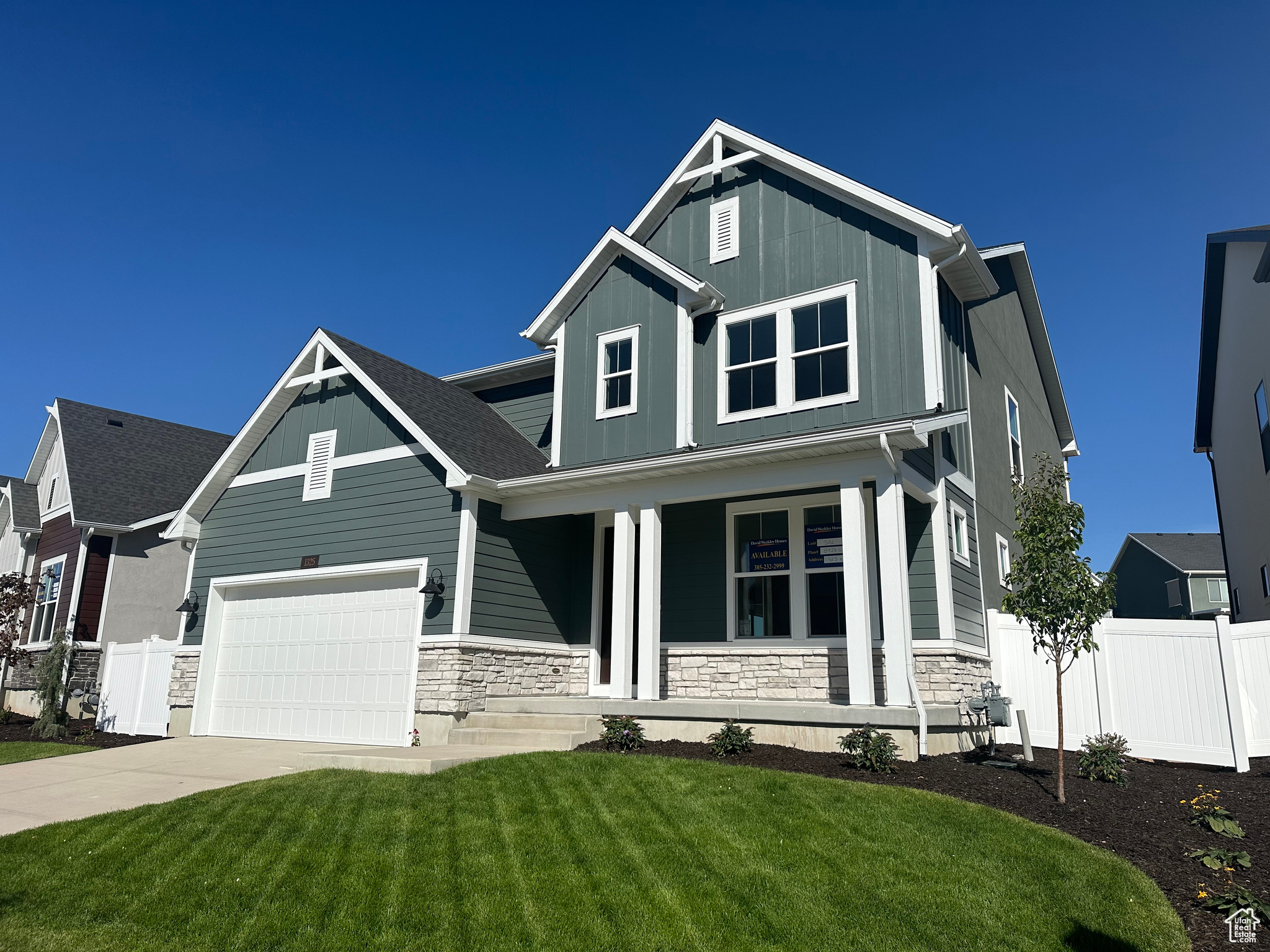 Craftsman-style home with a front lawn, a porch, and a garage