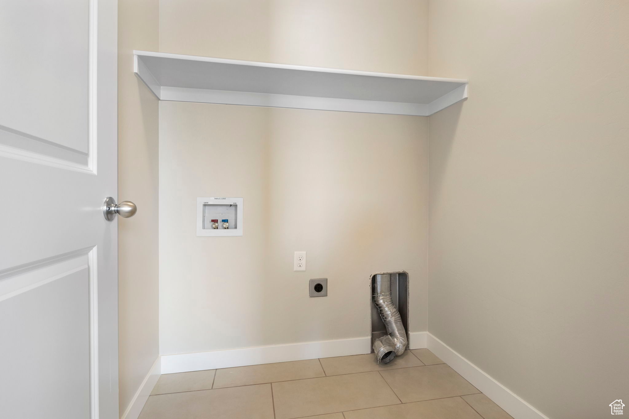 Laundry area with light tile patterned floors, hookup for an electric dryer, and washer hookup