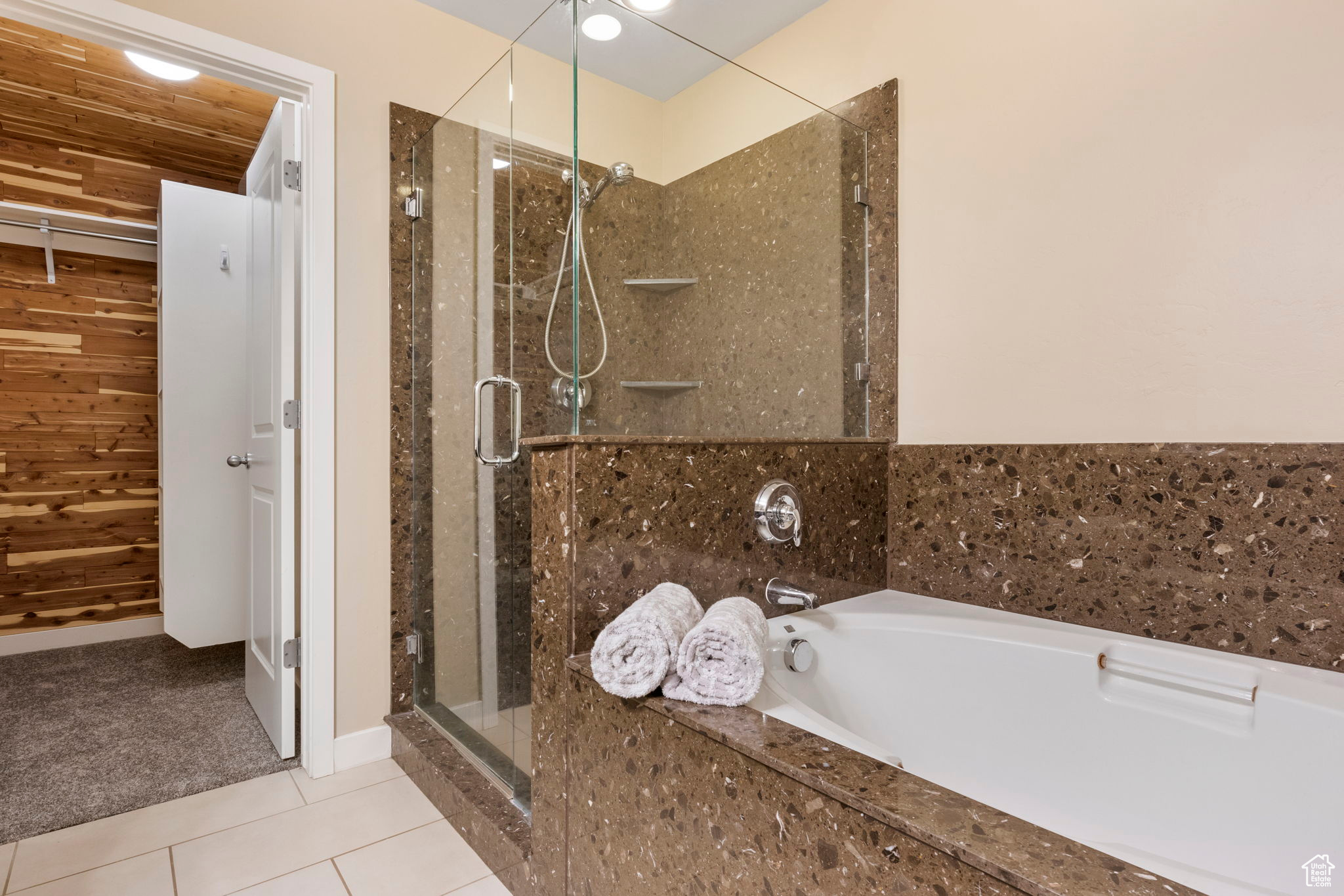 Bathroom with shower with separate bathtub, wooden ceiling, and tile patterned flooring