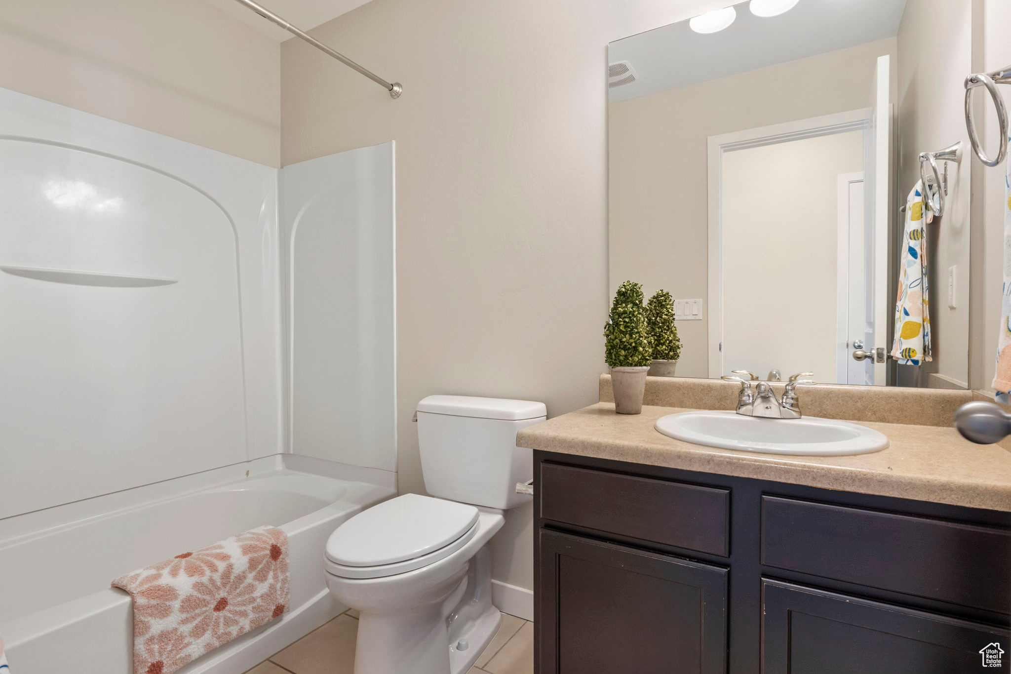 Full bathroom with tile patterned floors, shower / bath combination, toilet, and vanity