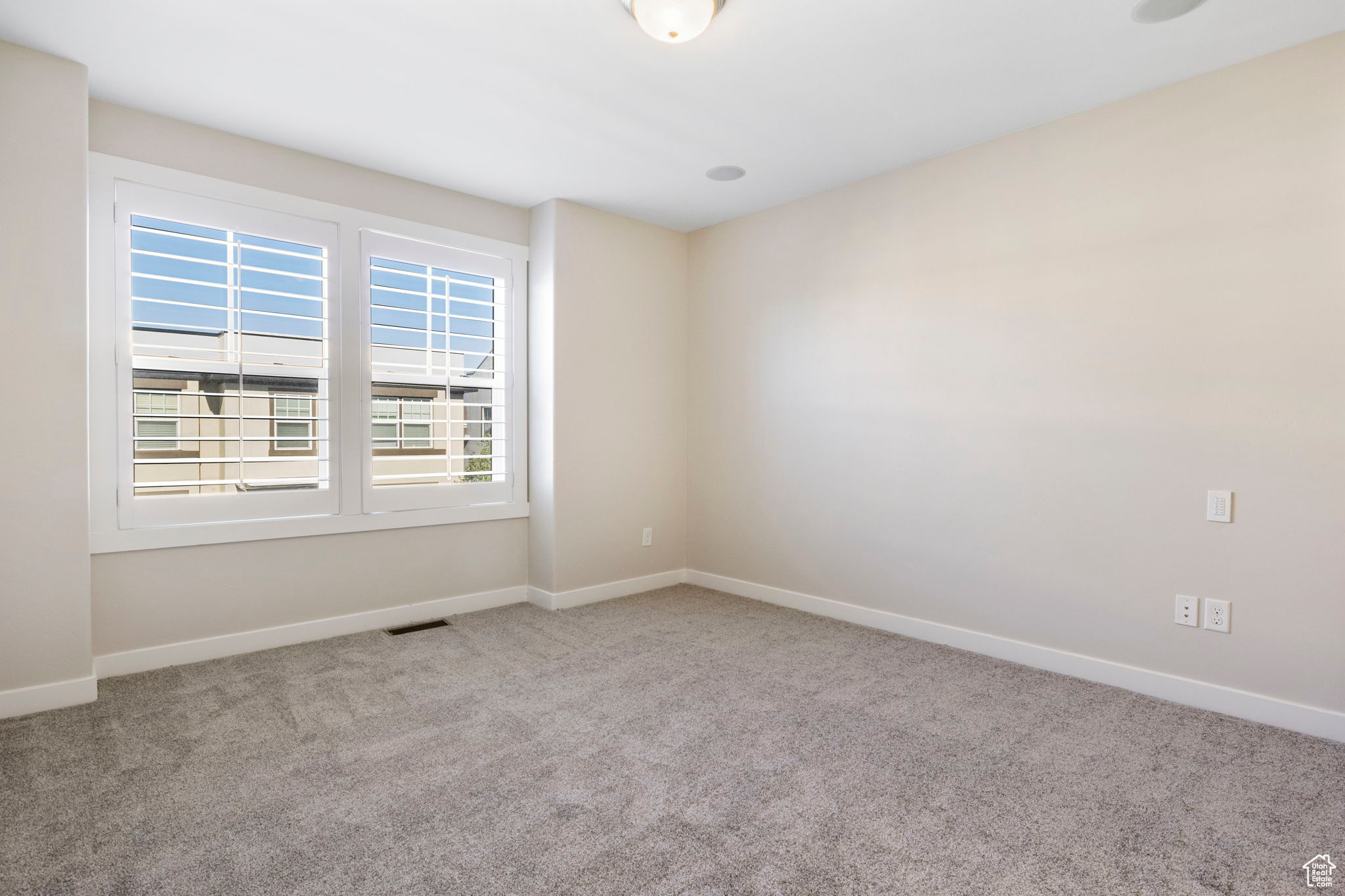 Spare room featuring light carpet