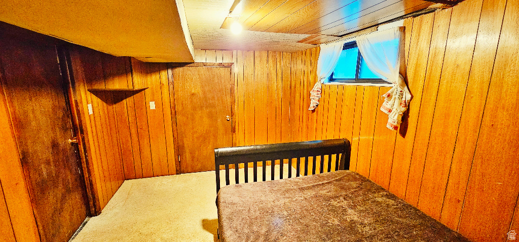 Bedroom featuring carpet and wood walls