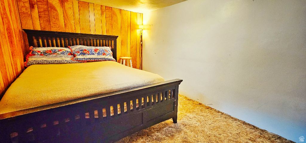 Carpeted bedroom with wood walls