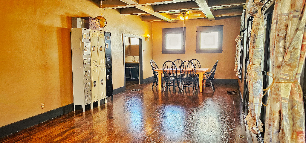 Dining area with beam ceiling, ceiling fan, sink, coffered ceiling, and dark hardwood / wood-style flooring