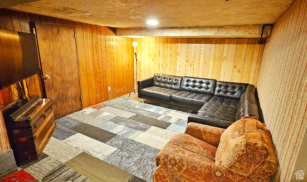 Carpeted living room with wood walls